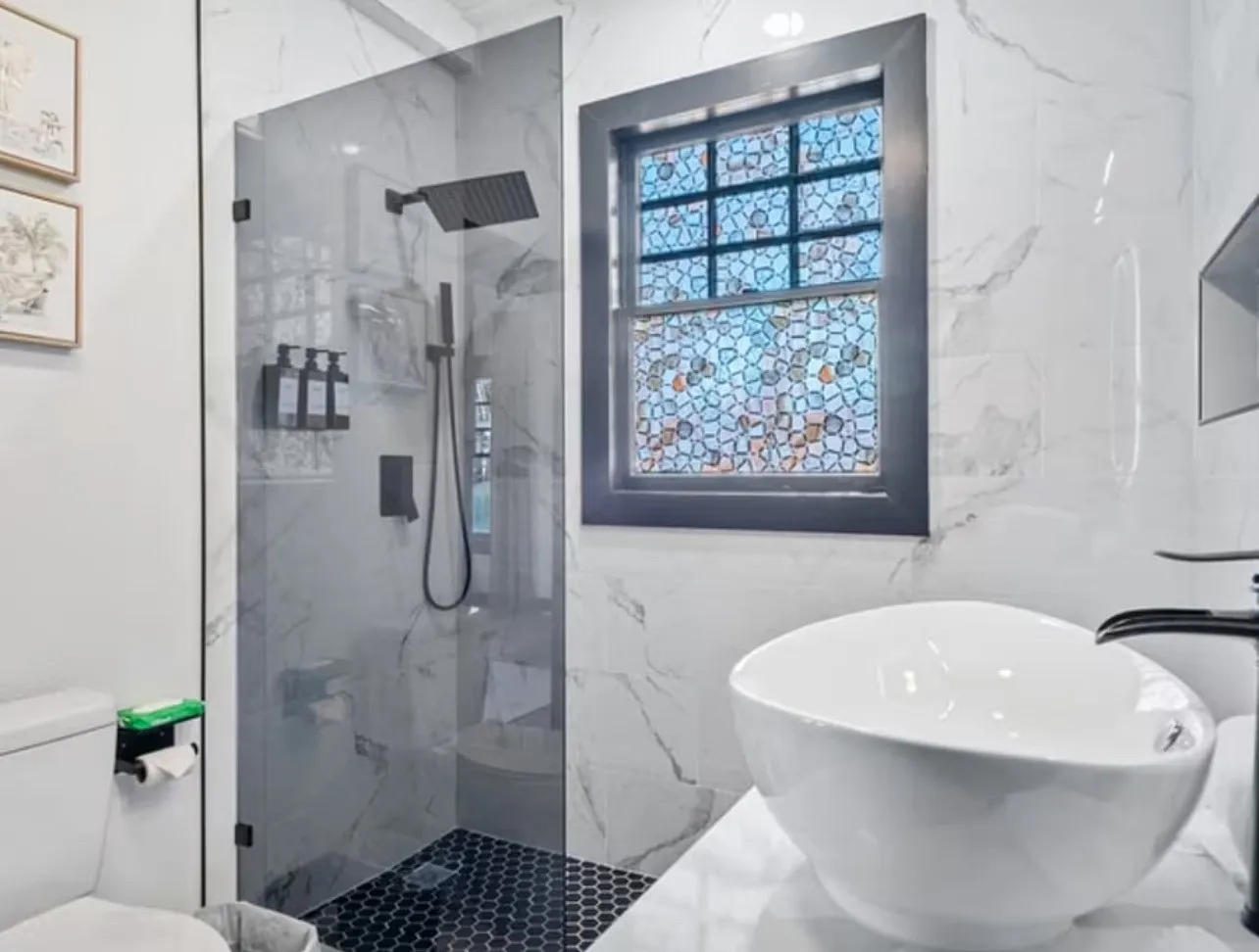 Bathroom with a marble finish shower and marble tiled flooring