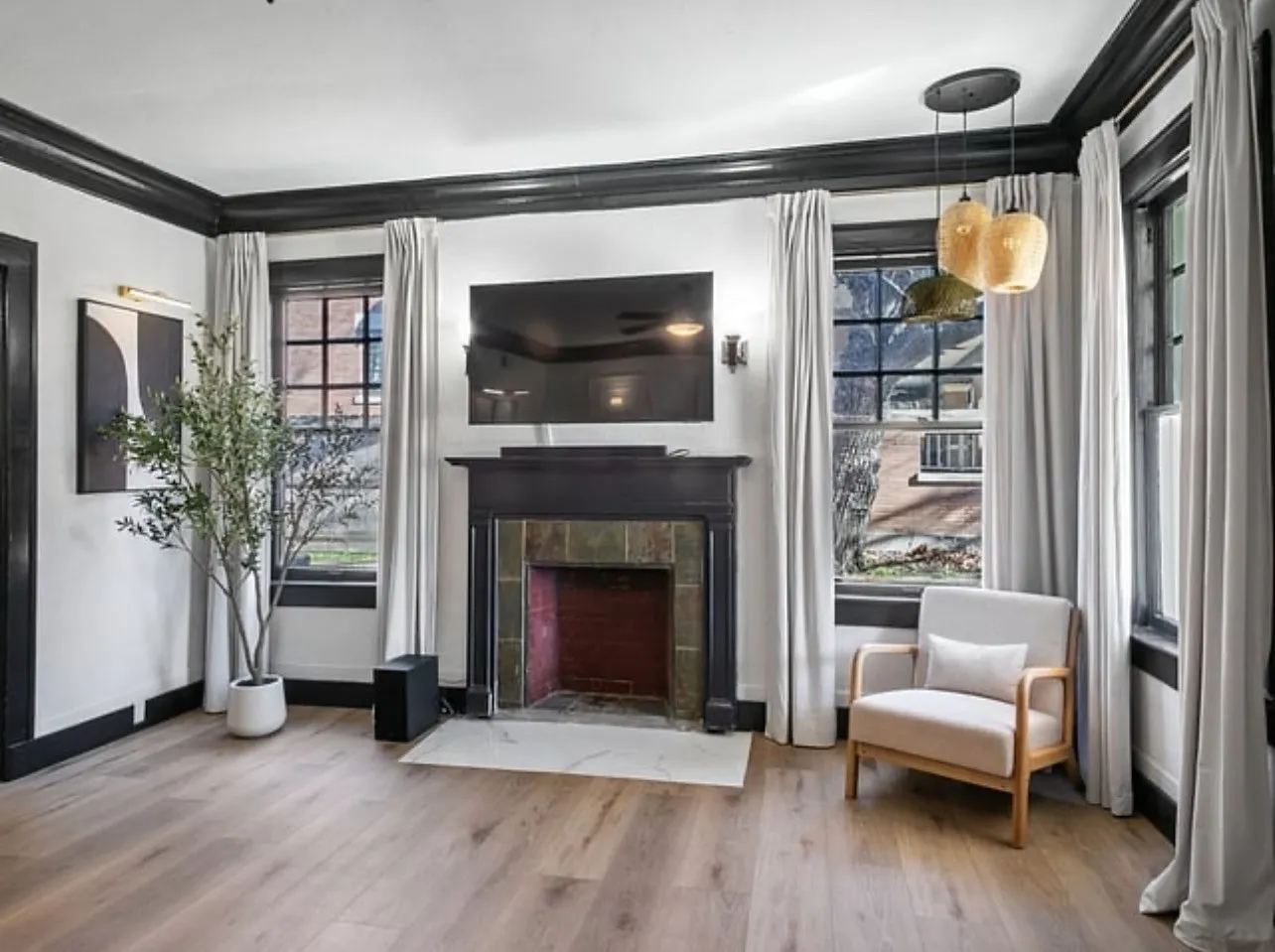 Living area with wood finished floors, crown molding, and a tile fireplace