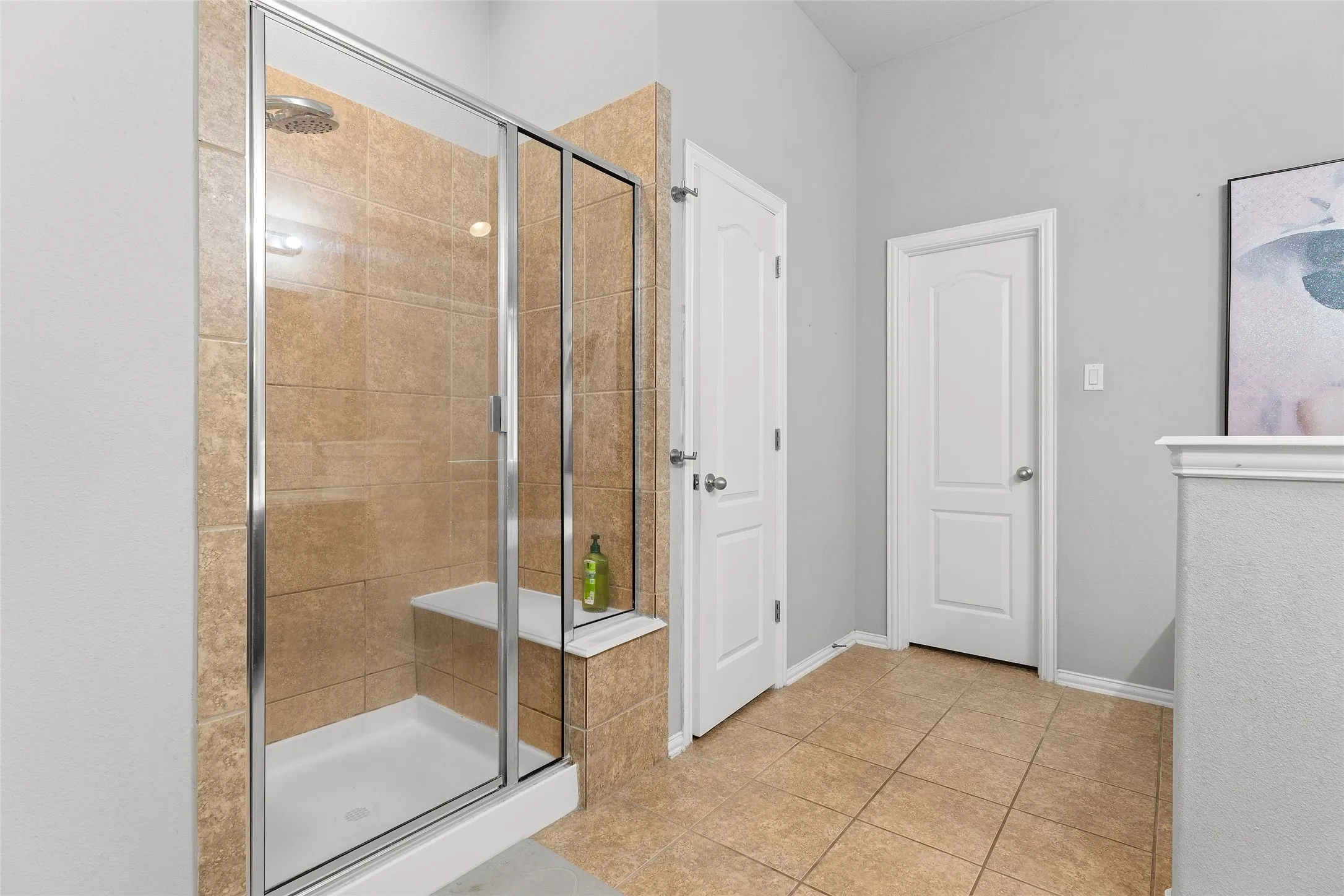 Full bathroom featuring a shower stall and light tile patterned floors