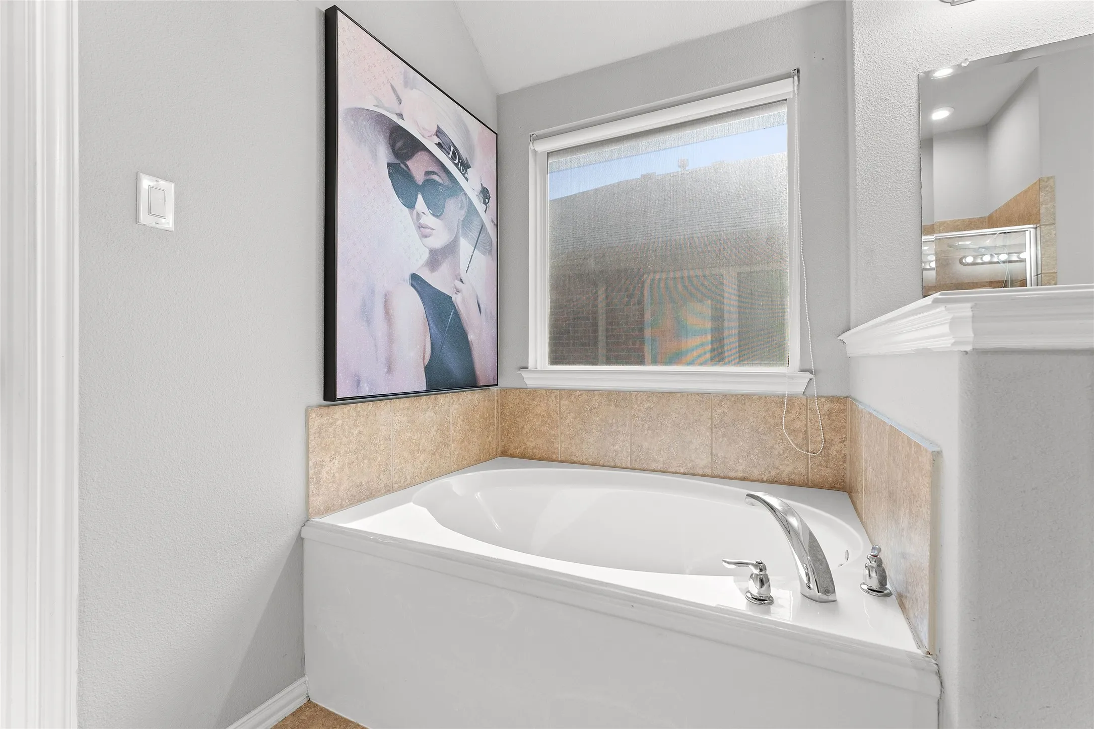 Bathroom with a textured wall, a garden tub, and tiled shower