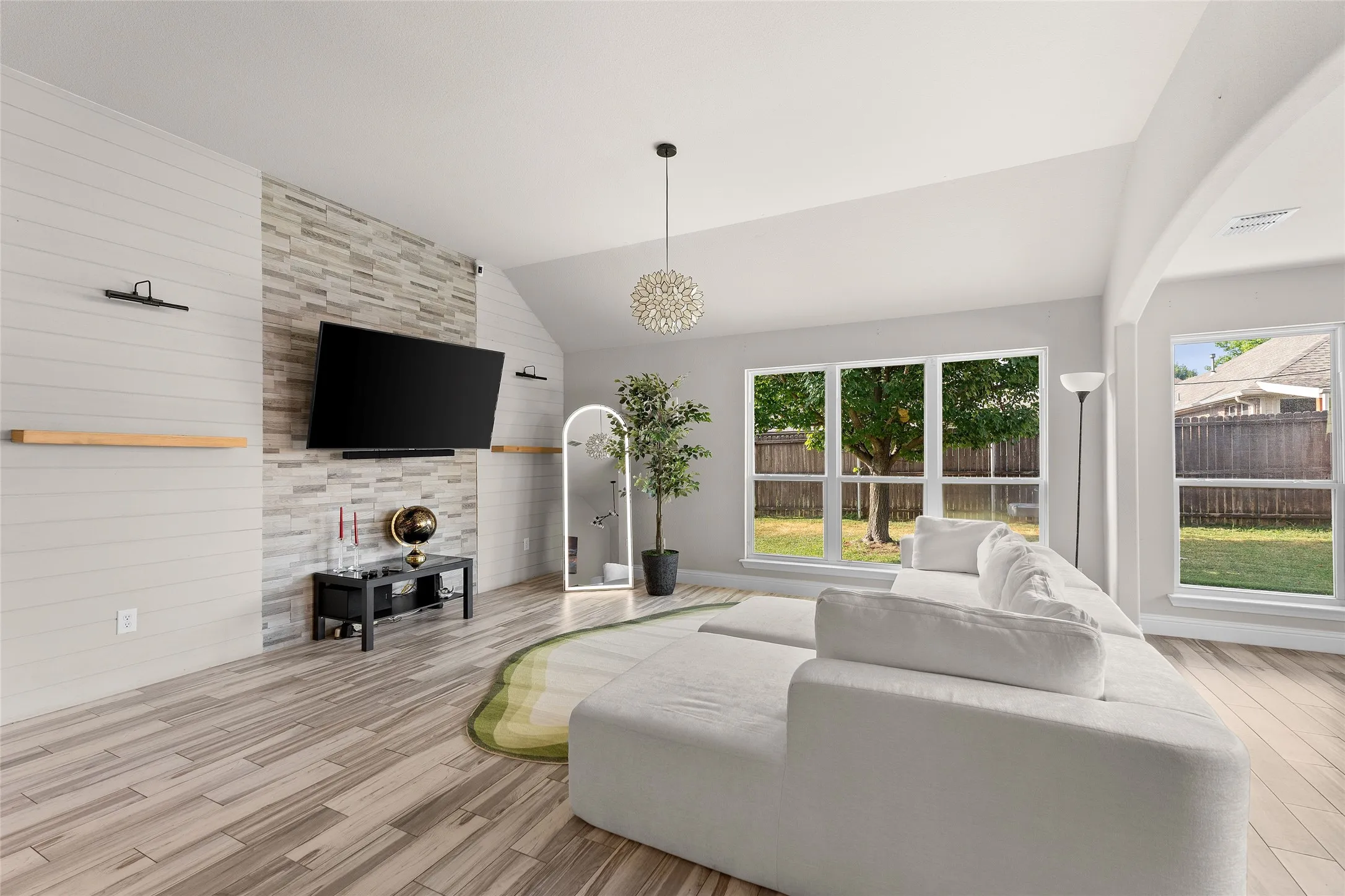 Living room with lofted ceiling, wood finished floors, and wooden walls