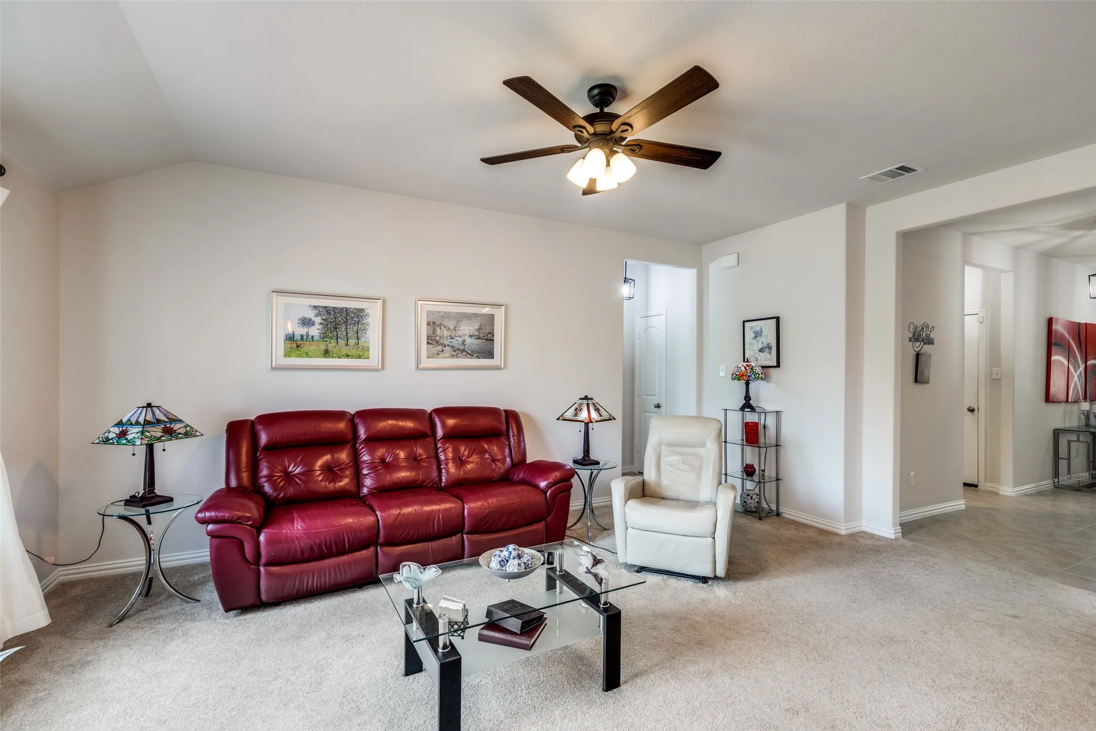 Carpeted living area with baseboards and ceiling fan