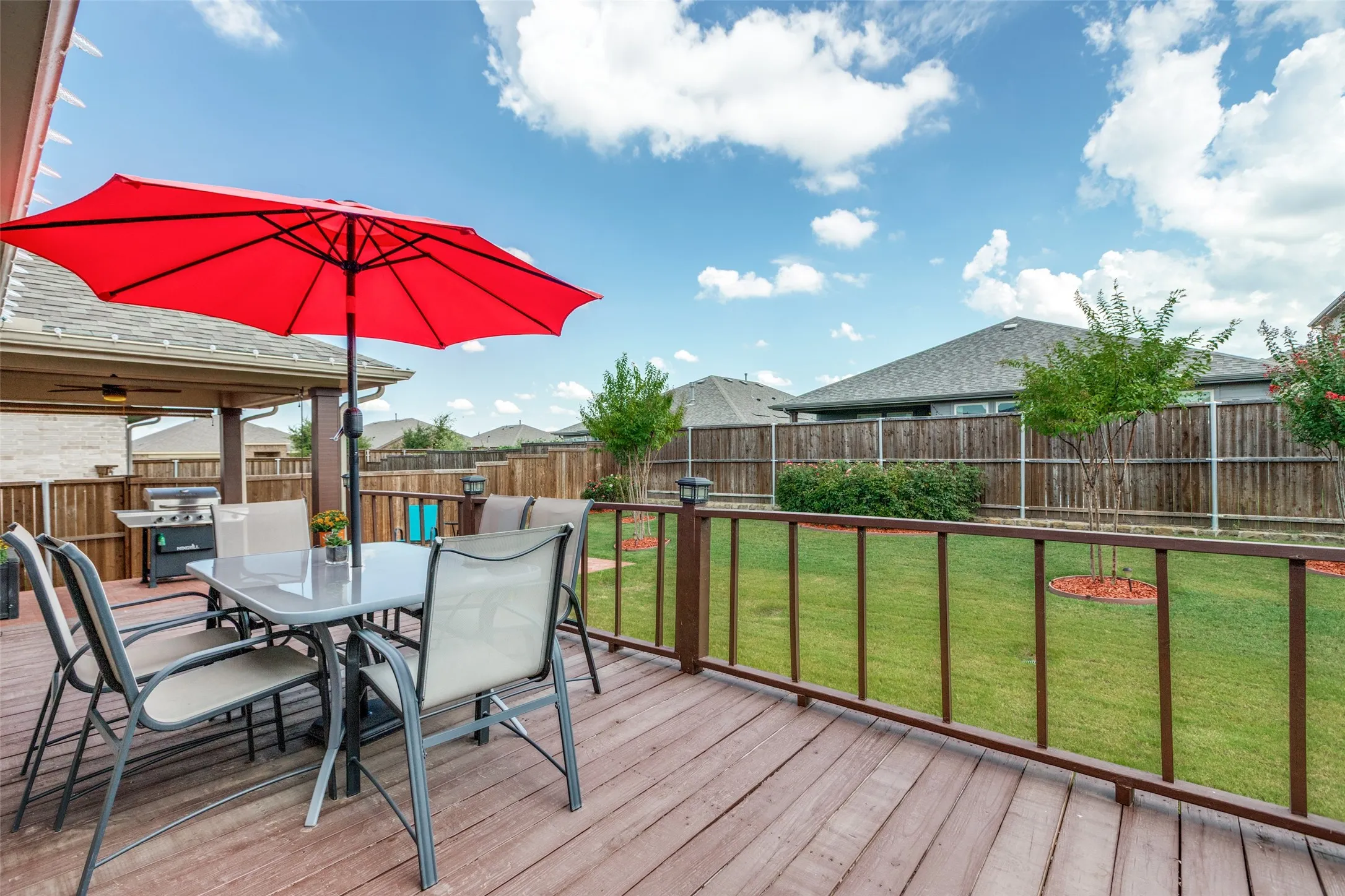 Deck with outdoor dining space, a fenced backyard, and area for grilling
