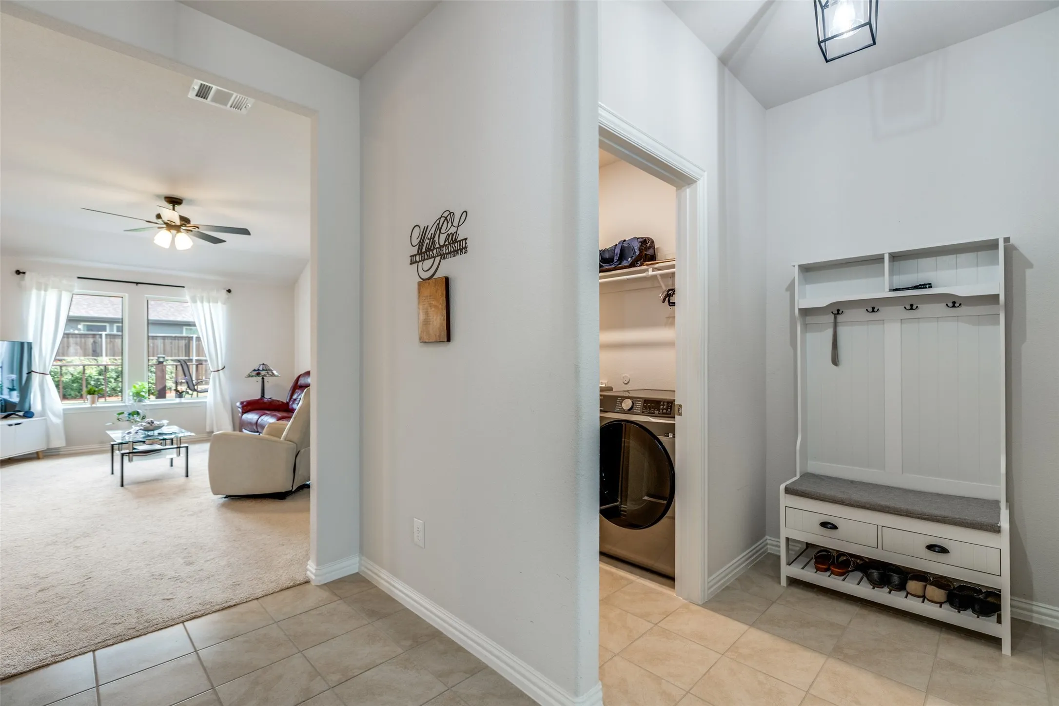 Mudroom with washer / dryer, light colored carpet, light tile patterned floors, and ceiling fan