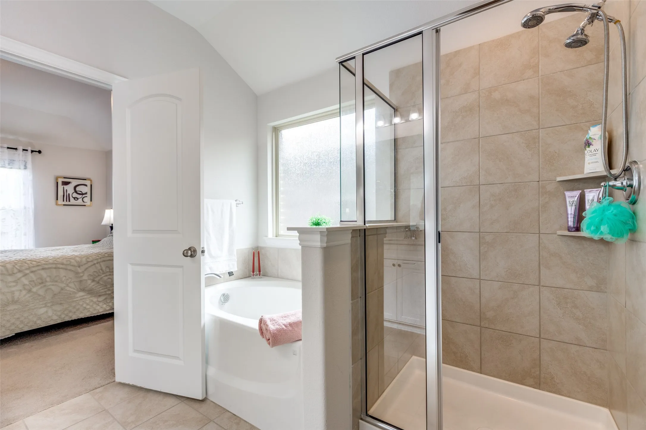 Full bath featuring a shower stall, a bath, connected bathroom, tile patterned floors, and lofted ceiling