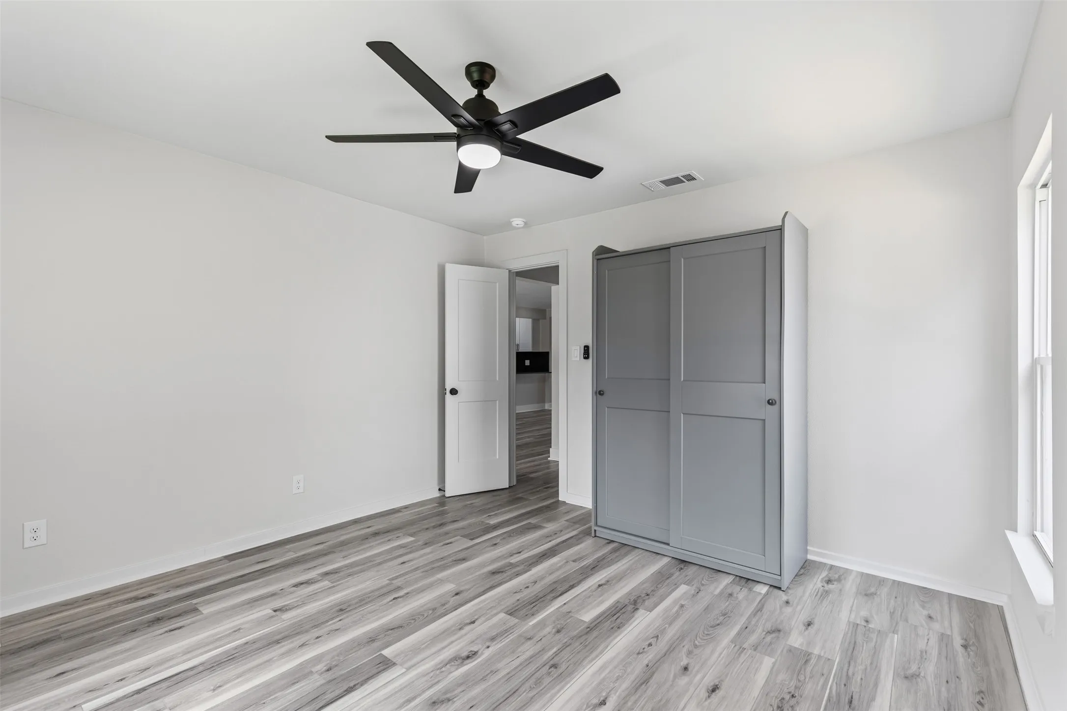 Unfurnished bedroom with light wood finished floors, a ceiling fan, and a closet