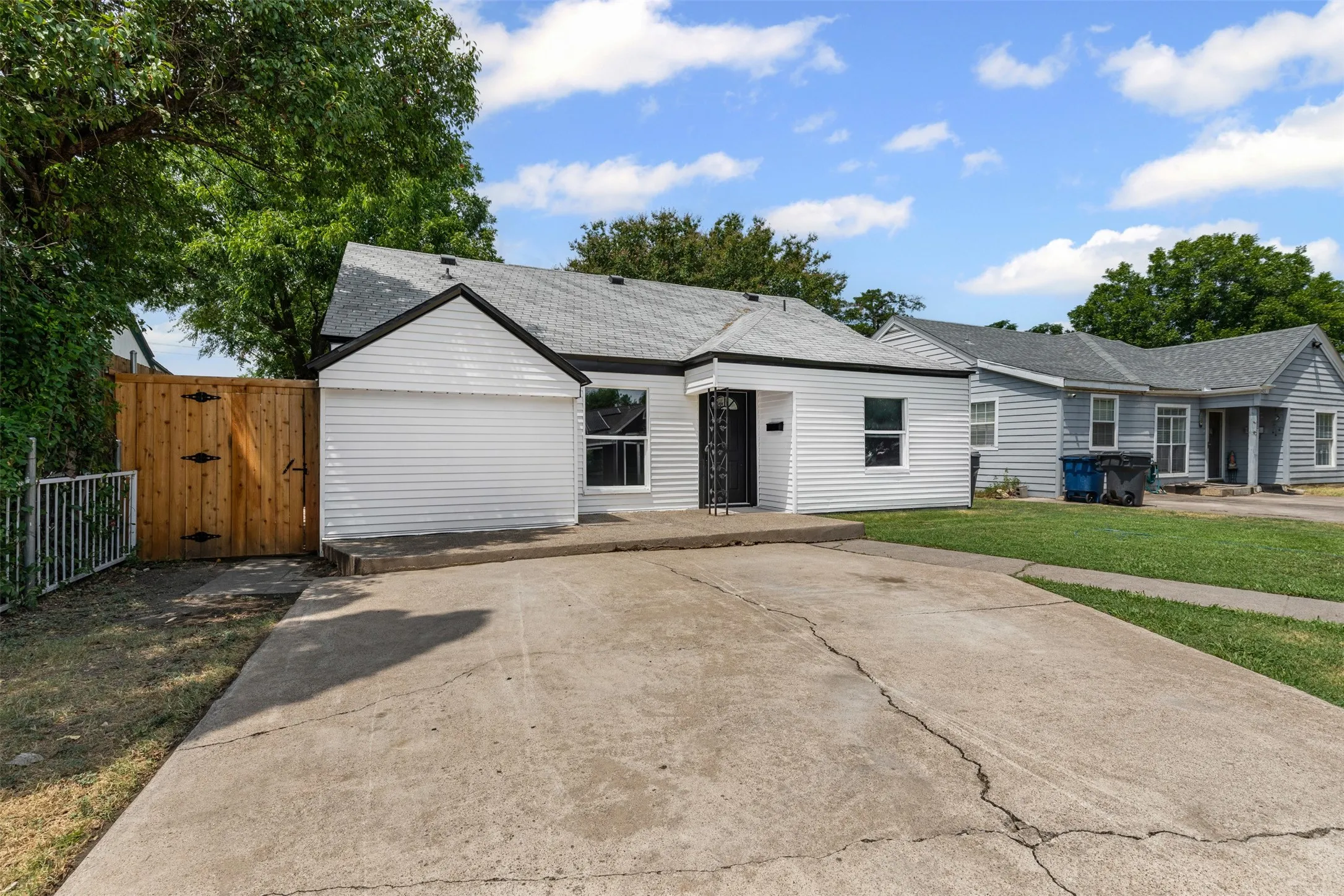 Single story home with a patio area, a gate, a front lawn, and a shingled roof