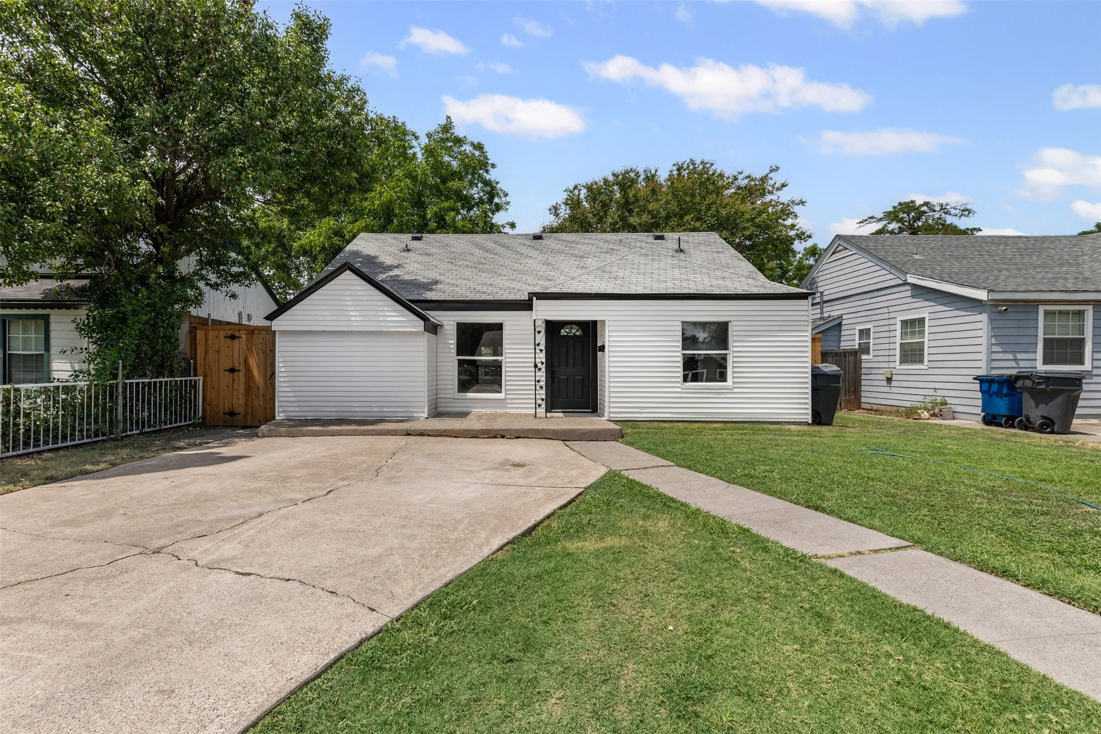 View of front facade with a shingled roof and concrete driveway