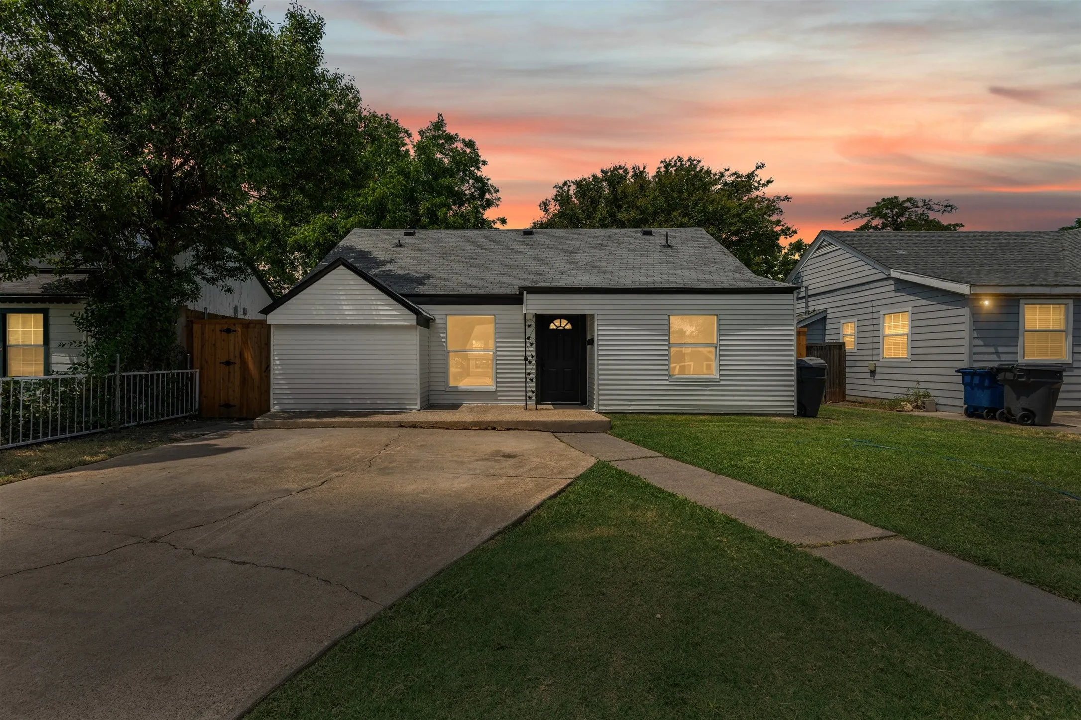 View of front of house with driveway and roof with shingles