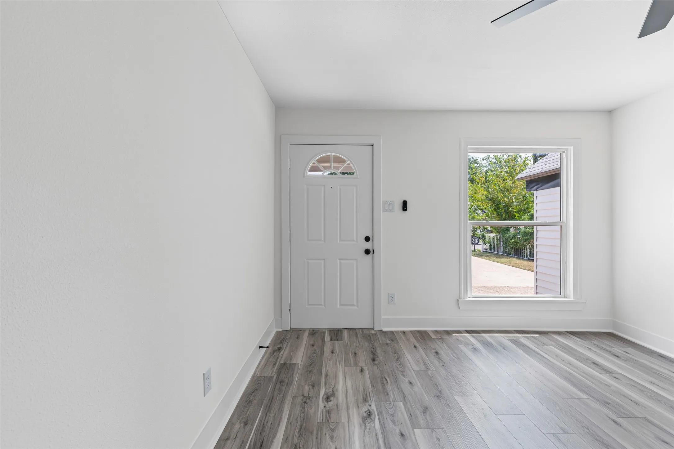 Entrance foyer featuring light wood-style floors and a ceiling fan