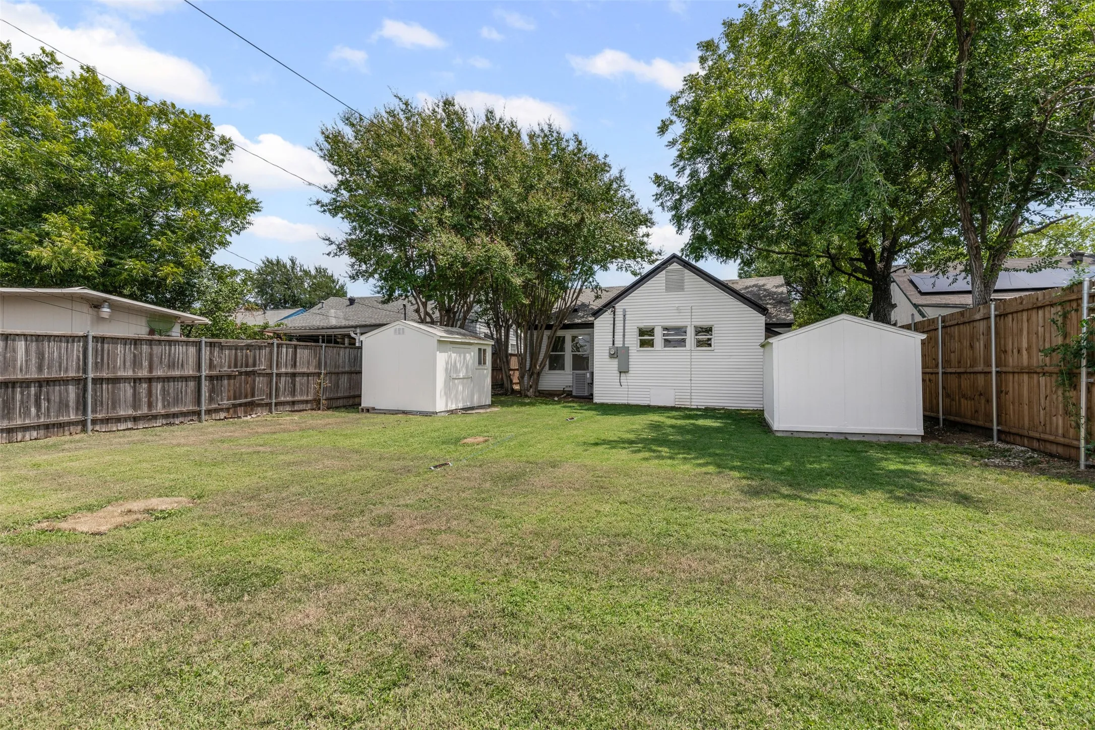 Fenced backyard with a storage unit