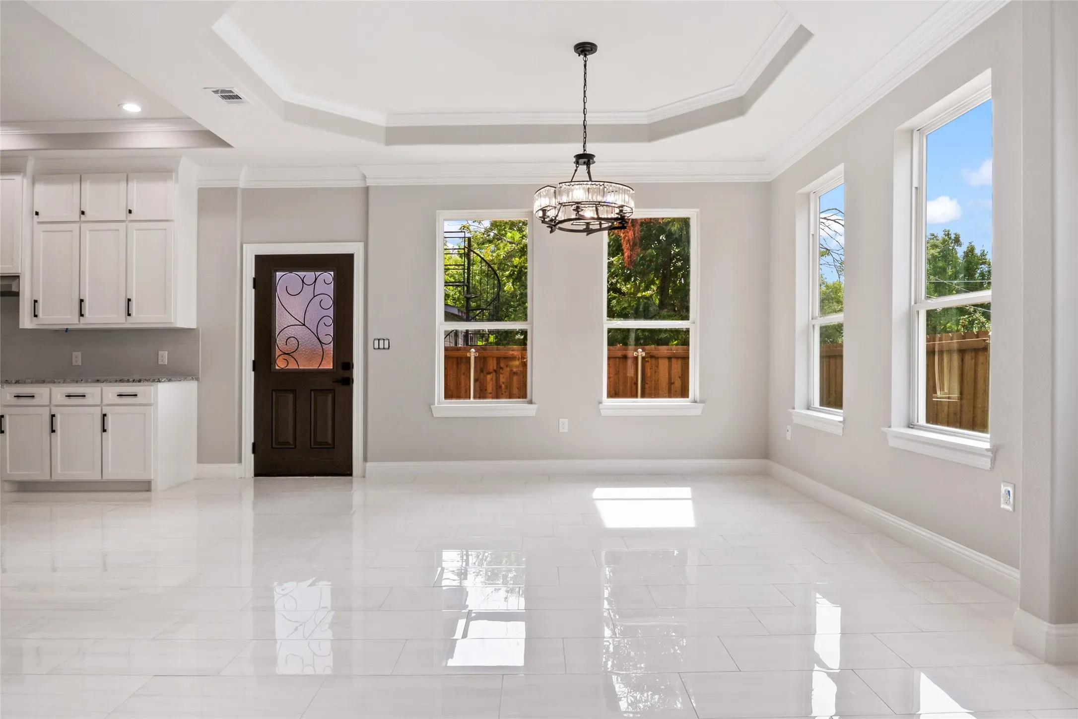 Unfurnished dining area featuring crown molding, a raised ceiling, and a chandelier