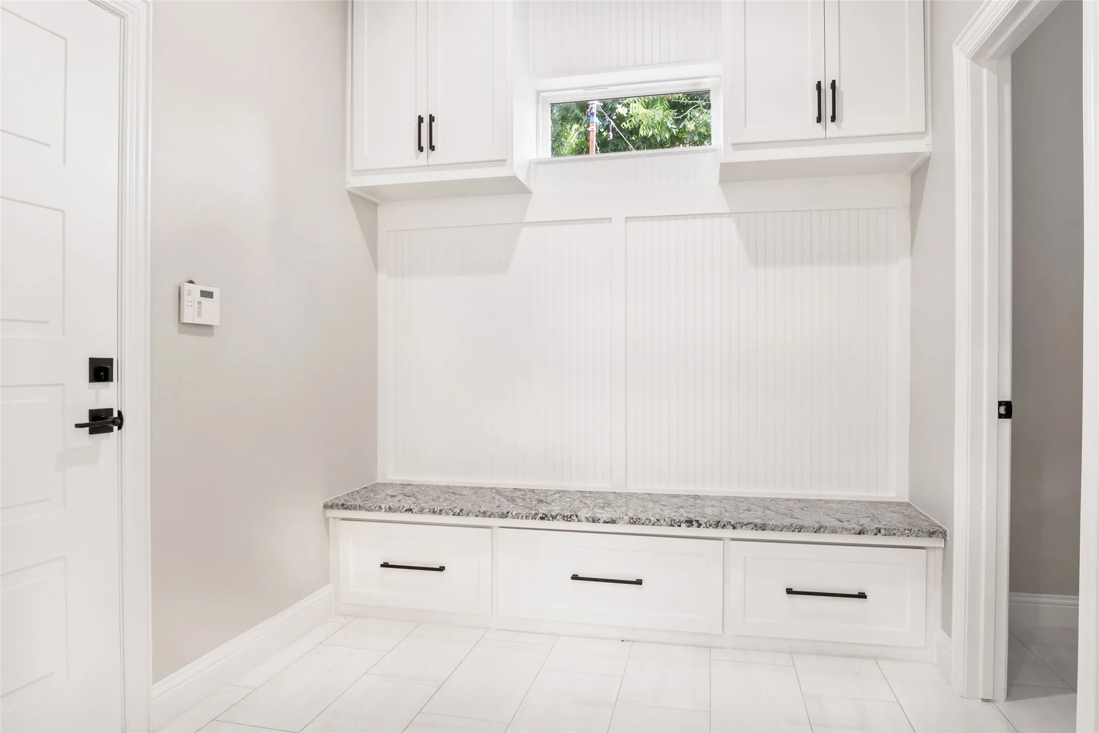 Mudroom with baseboards, custom solid wood cabinets, custom hardware, with drawer and a custom Granite top for long term duability top and beautiful flooring