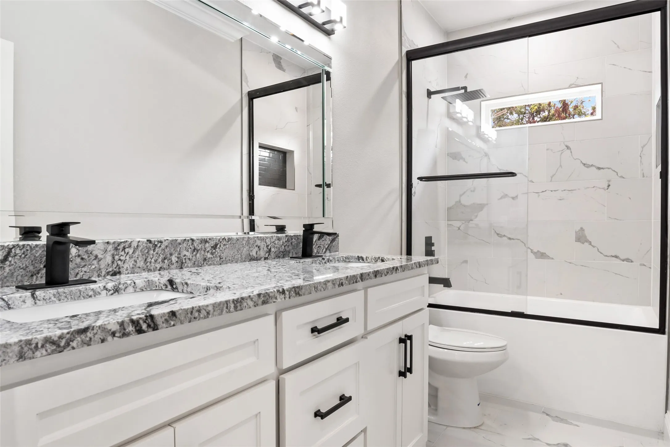 Full bath featuring double vanity, custom Granite and fixtures, with a chic enclosed tub / shower combo