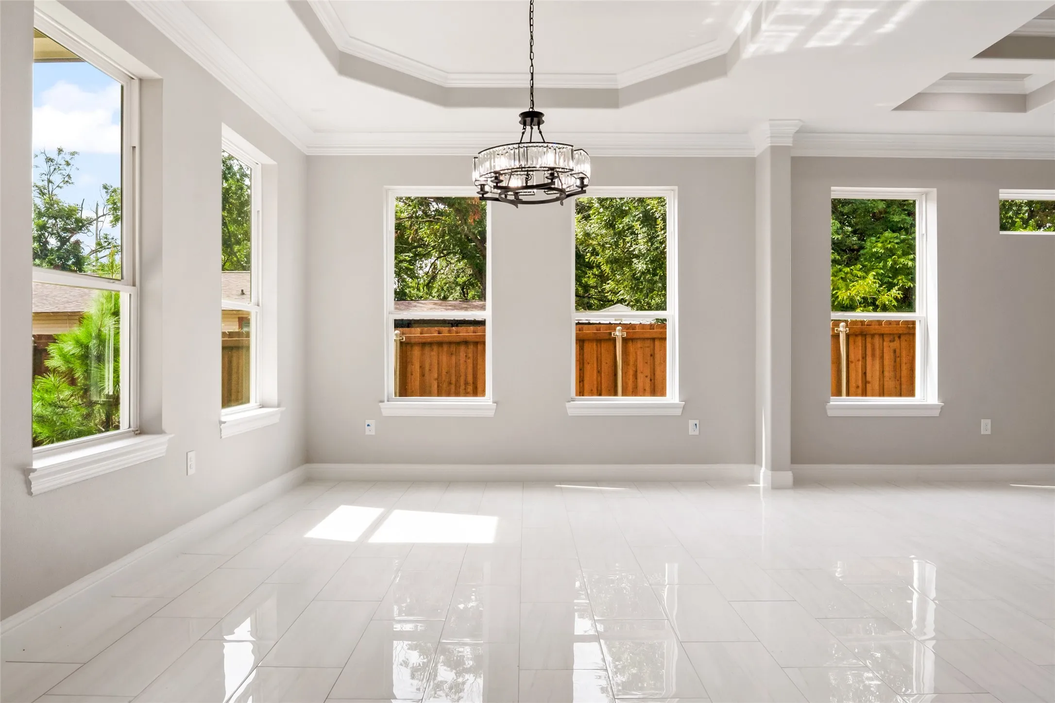 Unfurnished dining area featuring a tray ceiling, crown molding, and a chandelier