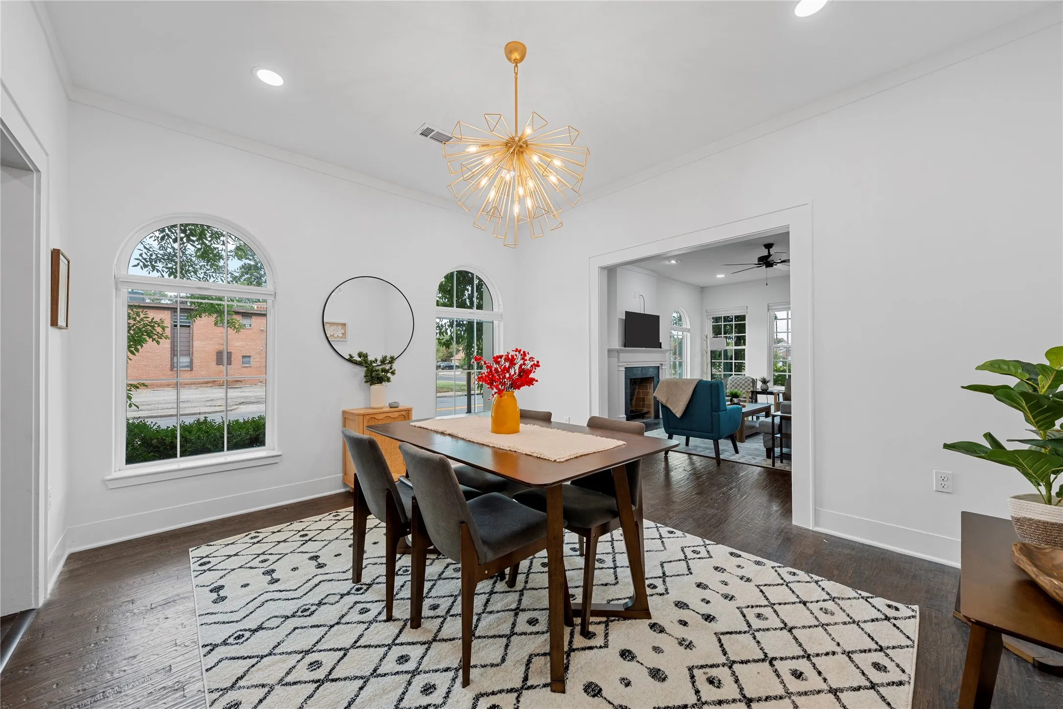 Dining space featuring crown molding, dark wood-style floors, recessed lighting, a fireplace, and a chandelier