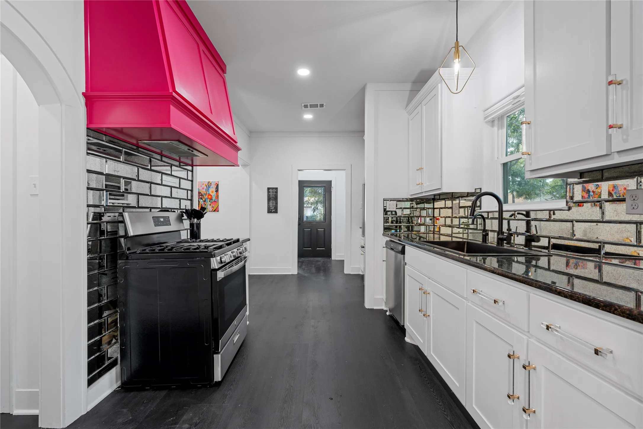 Kitchen with decorative backsplash, stainless steel appliances, recessed lighting, dark wood-style floors, and pendant lighting