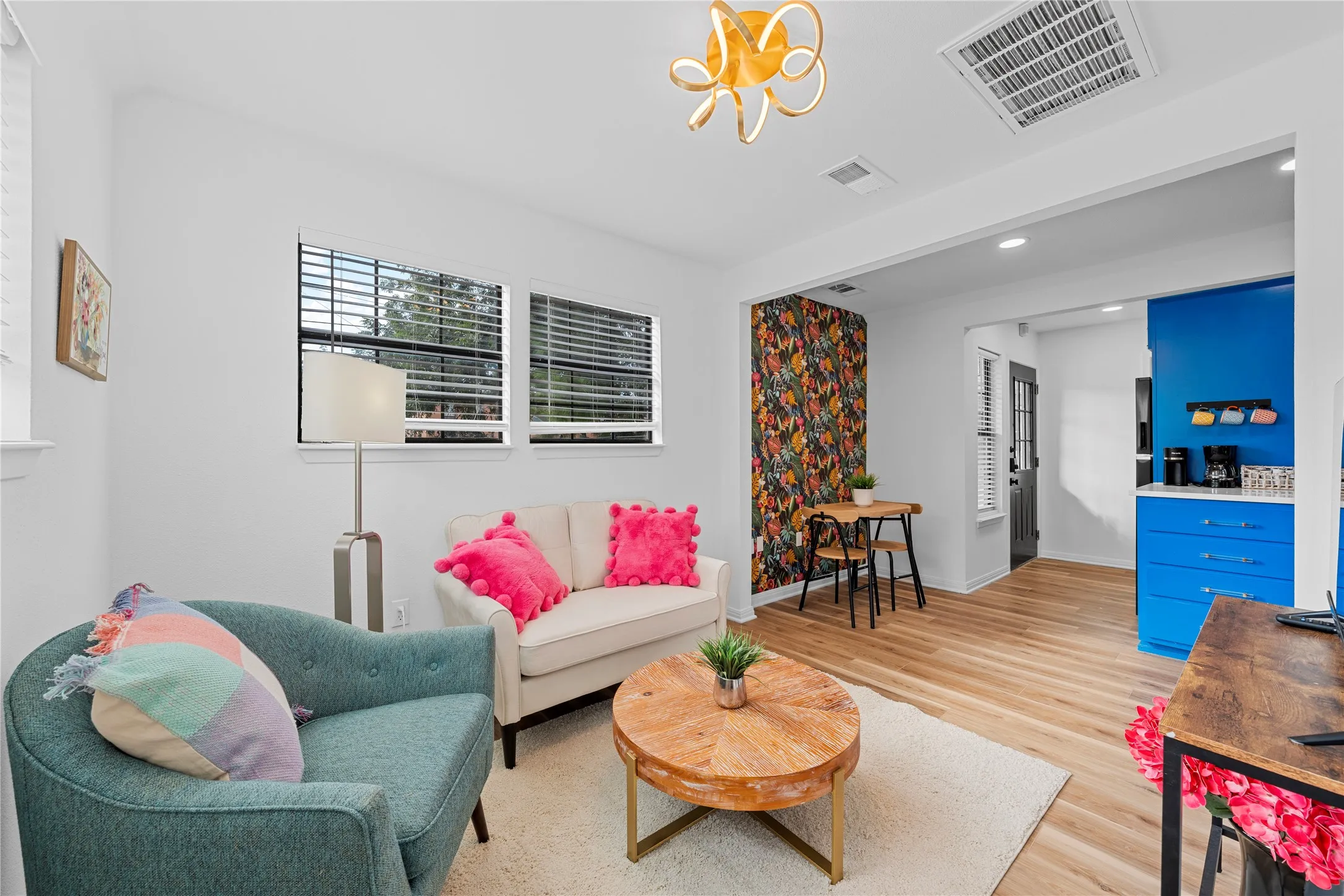Living area featuring light wood-style floors, recessed lighting, and a chandelier