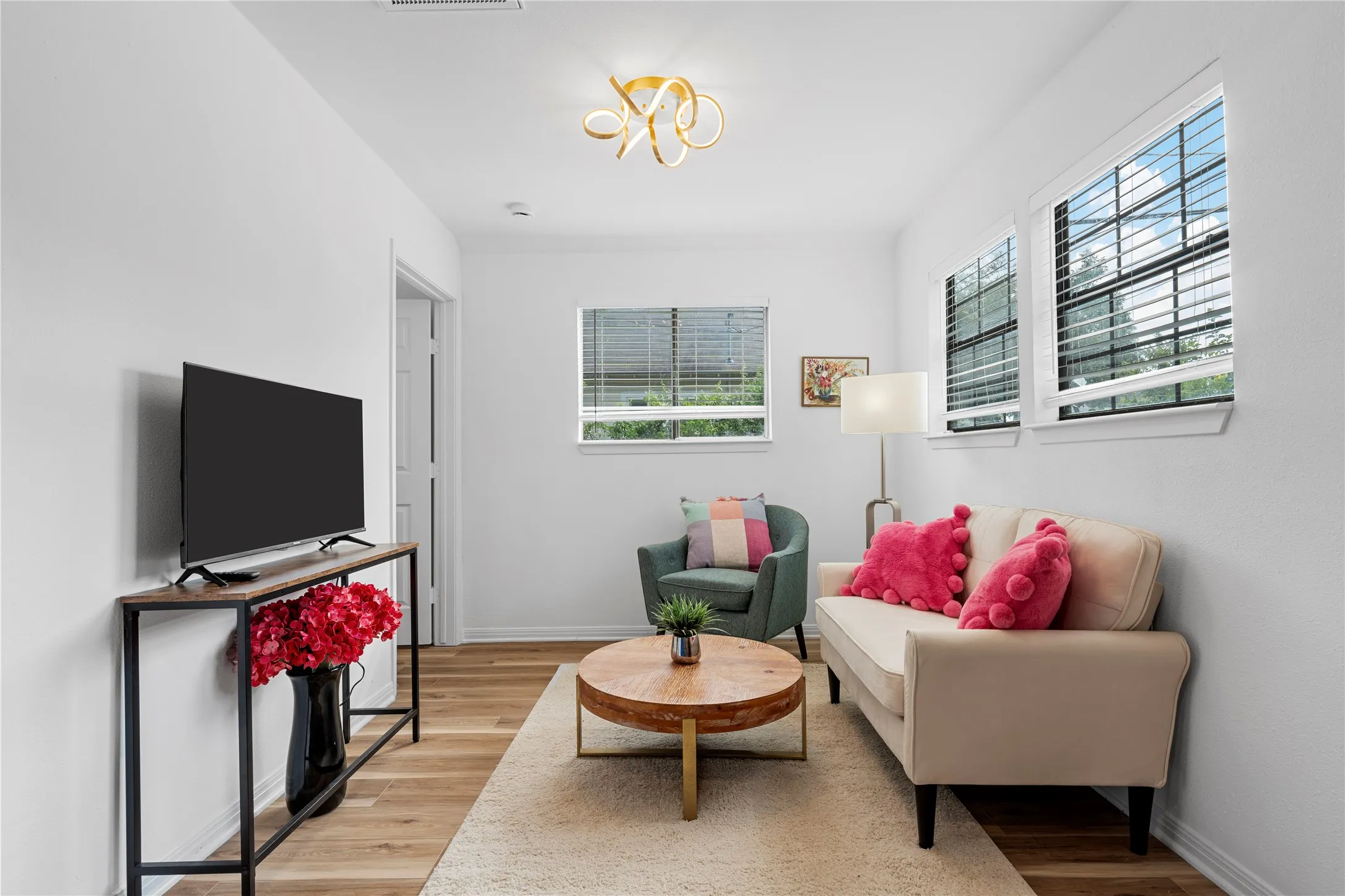 Living area with wood finished floors and a chandelier
