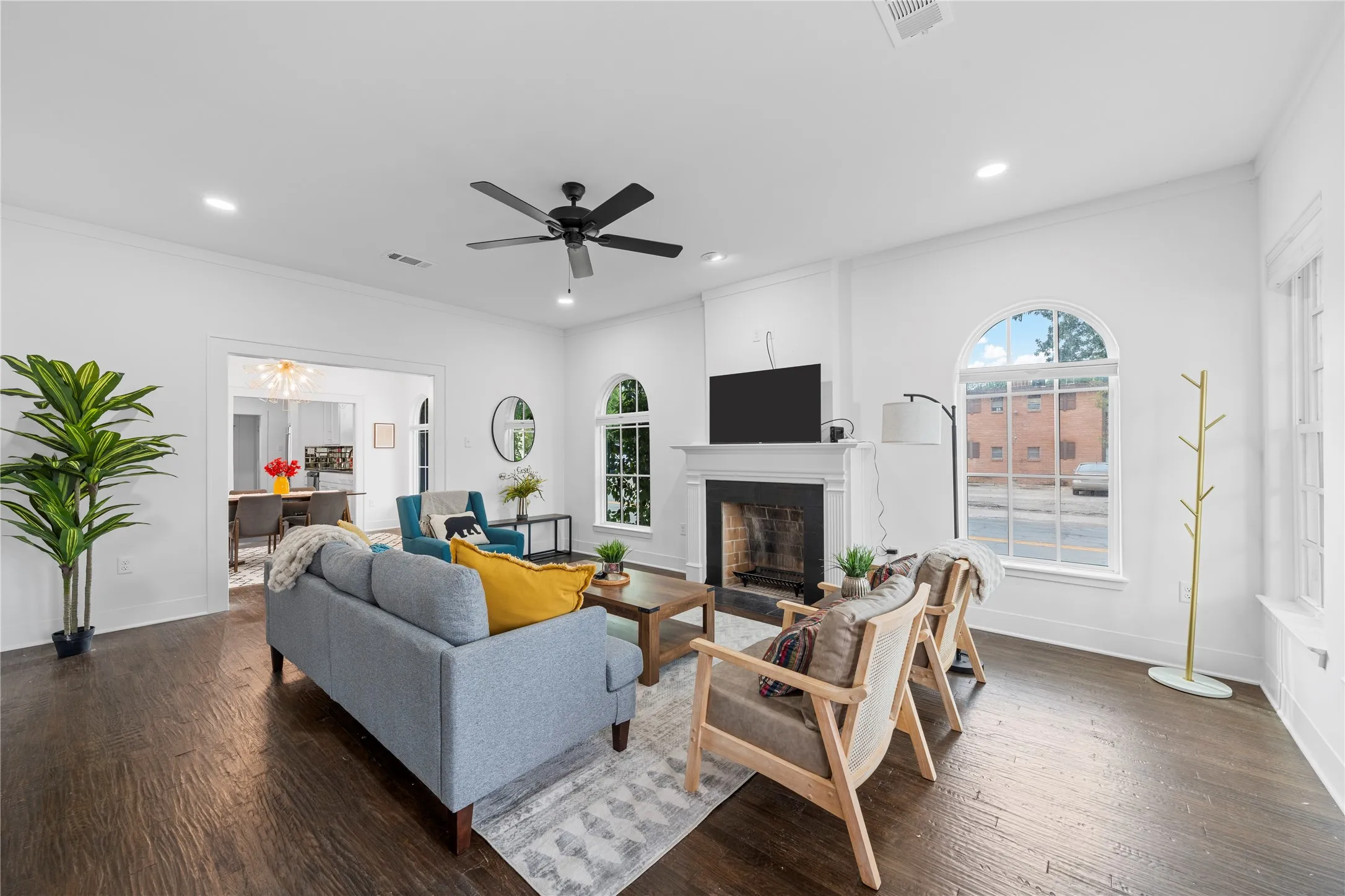 Living room featuring crown molding, dark wood-style flooring, a fireplace with flush hearth, recessed lighting, and ceiling fan