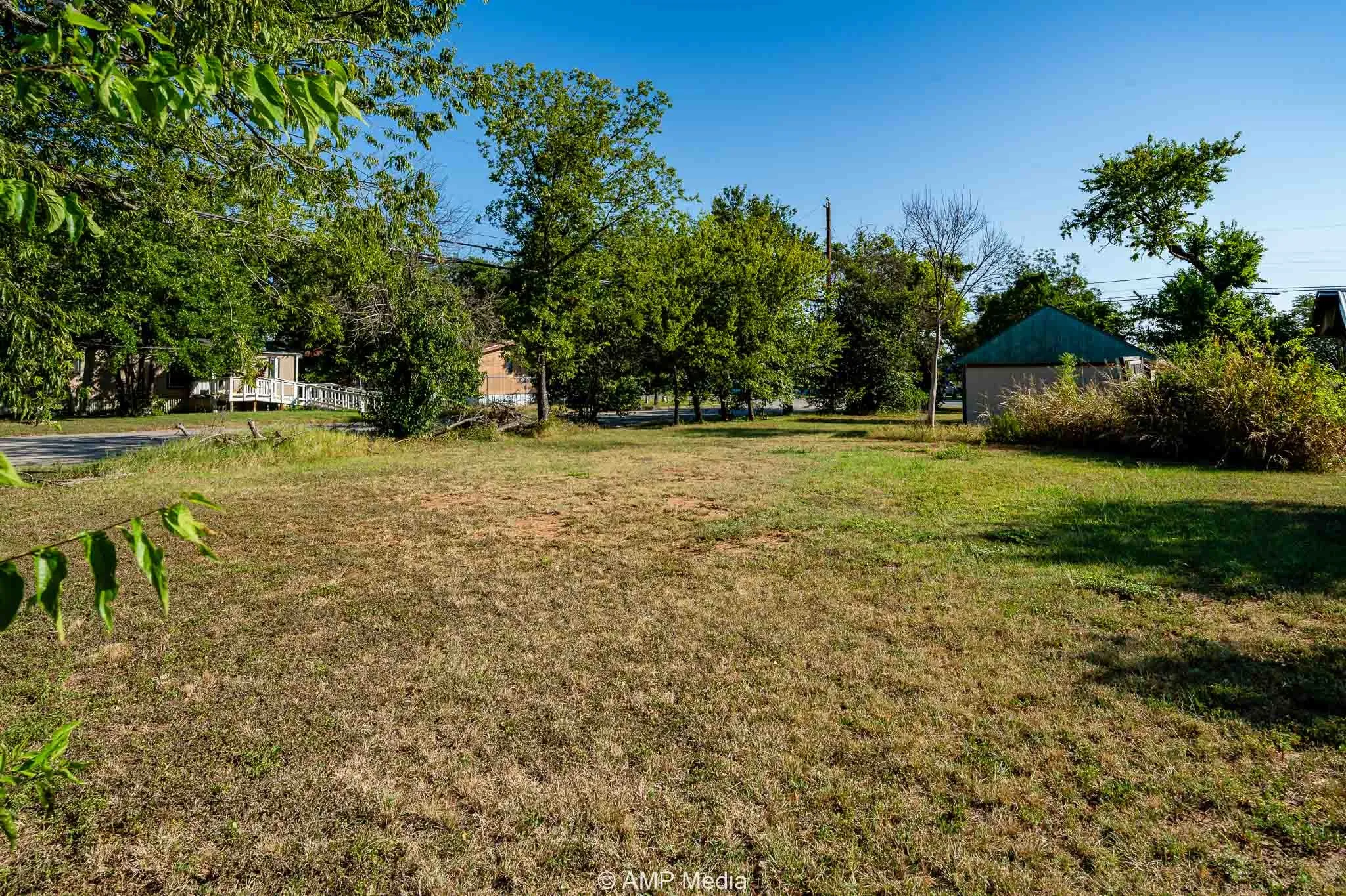 View of green lawn with view of wooded area