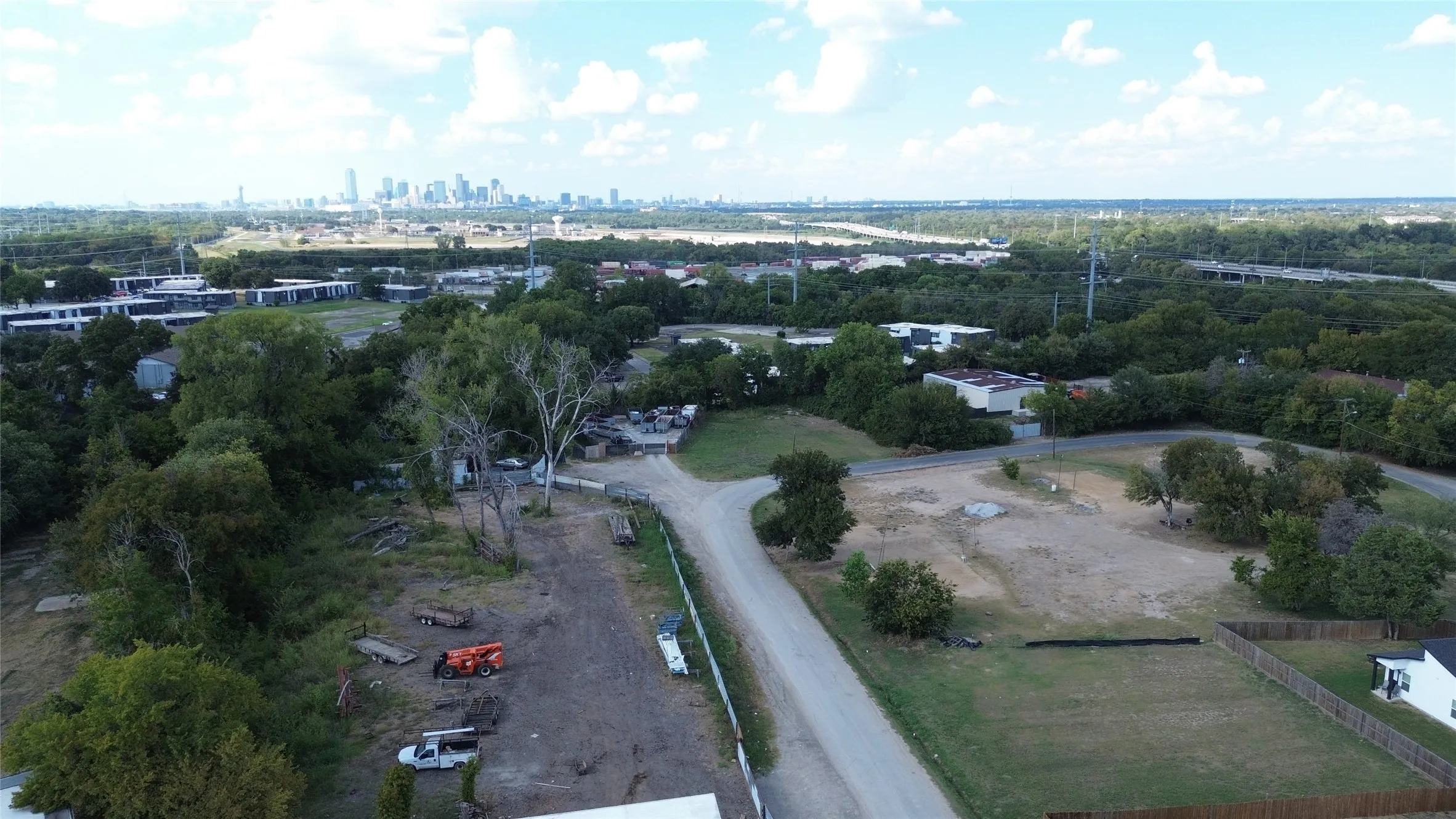 Aerial view of property's location with city skyline and a tree filled landscape
