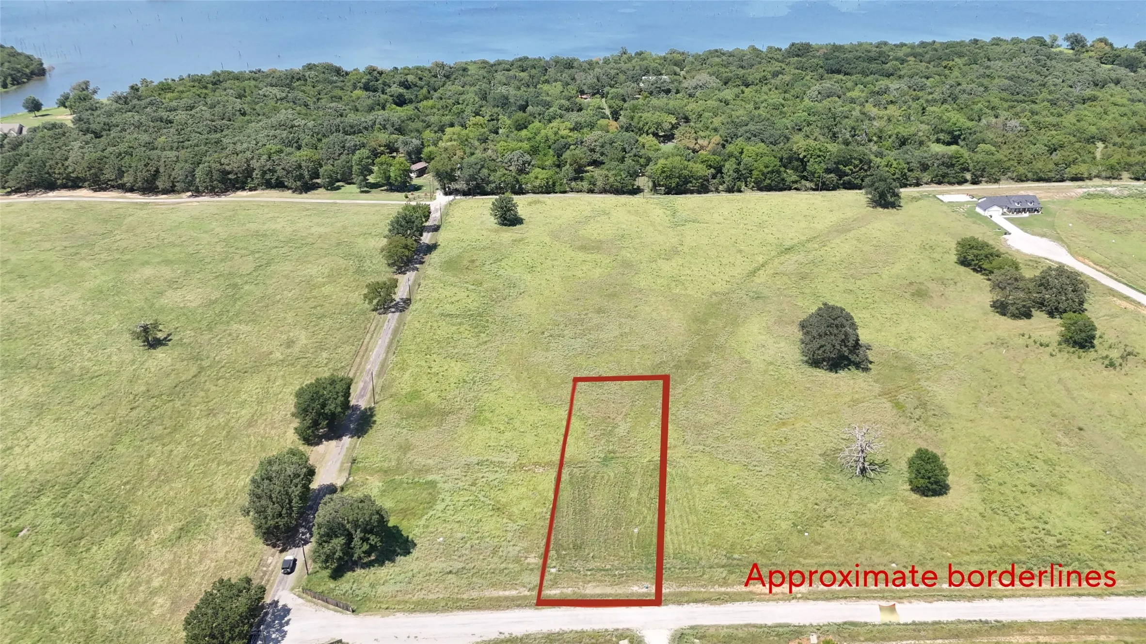 Aerial view of sparsely populated area featuring property parcel outlined and a forest