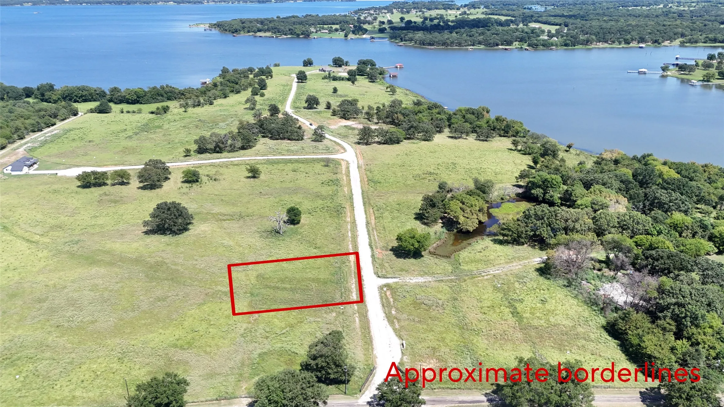Aerial view of property and surrounding area with property parcel outlined and a nearby body of water