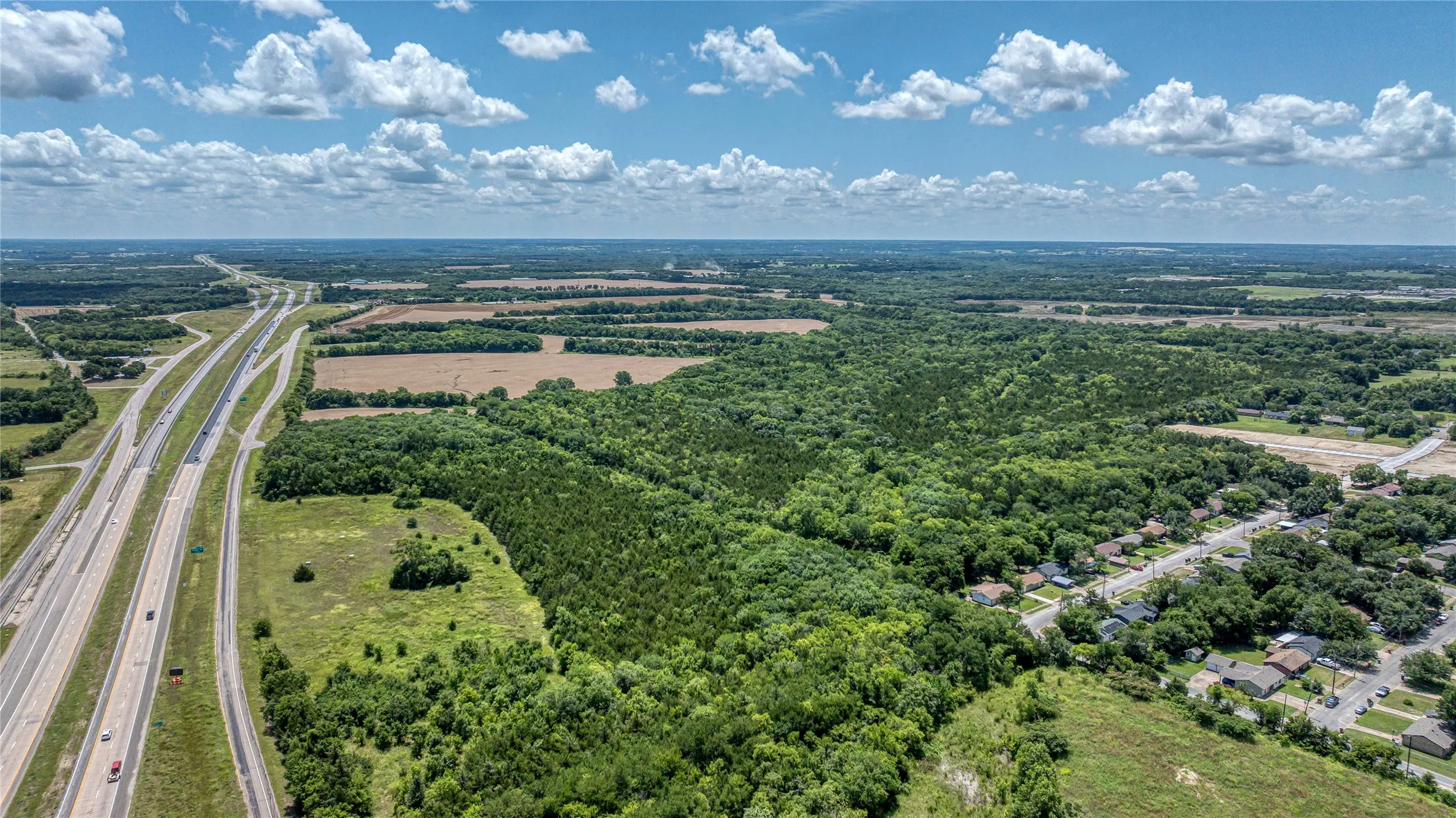 Aerial view of a major roadway and a heavily wooded area