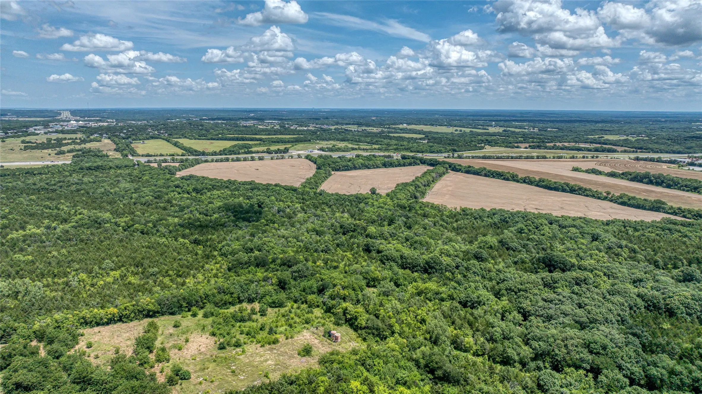 Overview of rural landscape with abundant farmland and a heavily wooded area