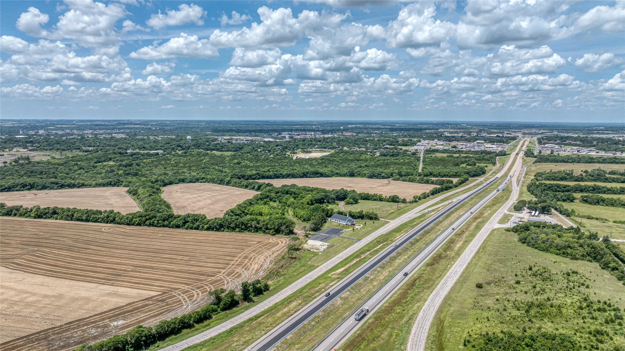 Bird's eye view of a main thoroughfare and a tree filled landscape