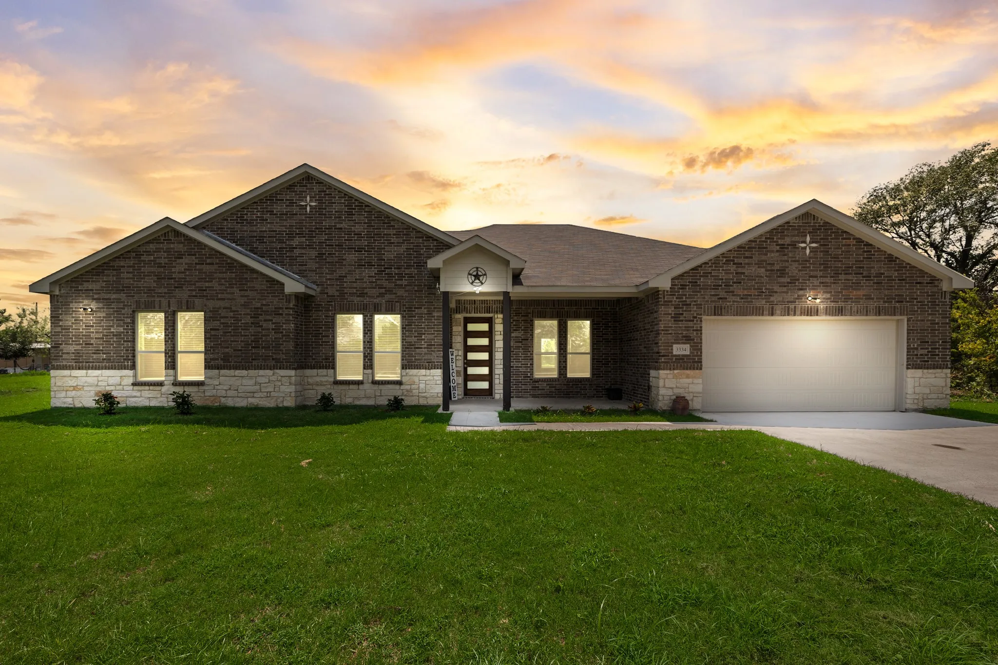 View of front of home with concrete driveway, a lawn, a garage, and brick siding