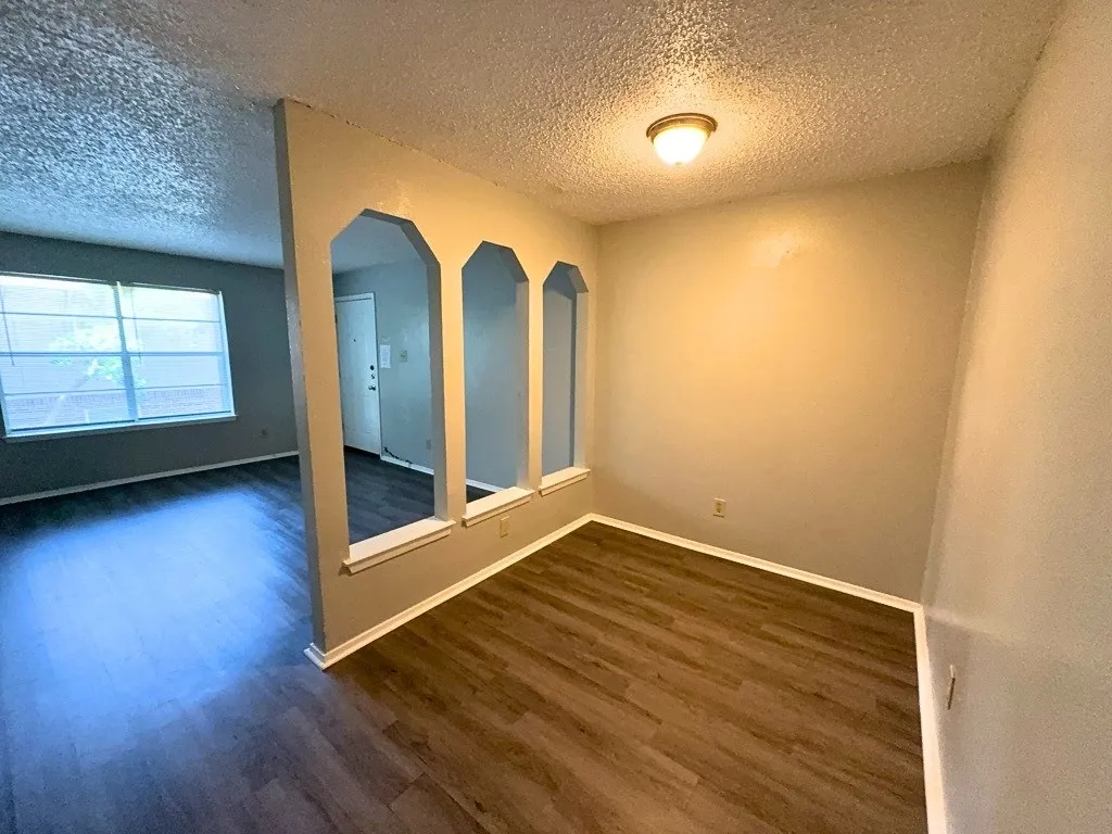 Dining area with arched openings to living room