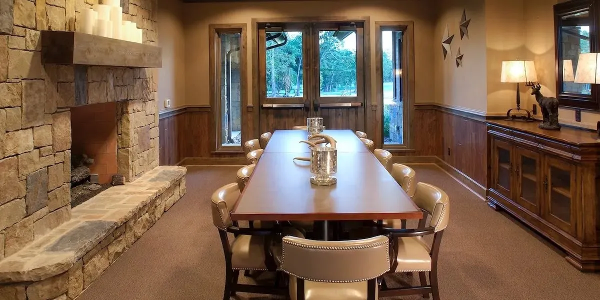Carpeted dining room featuring wainscoting