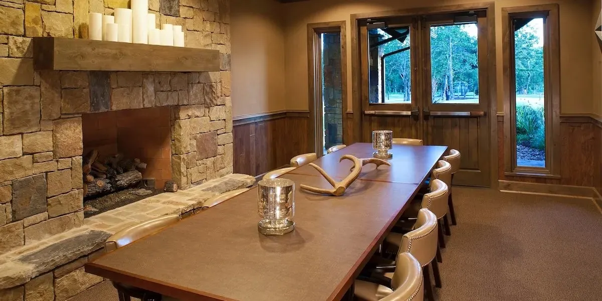 Carpeted home office featuring a fireplace, a wainscoted wall, and wooden walls