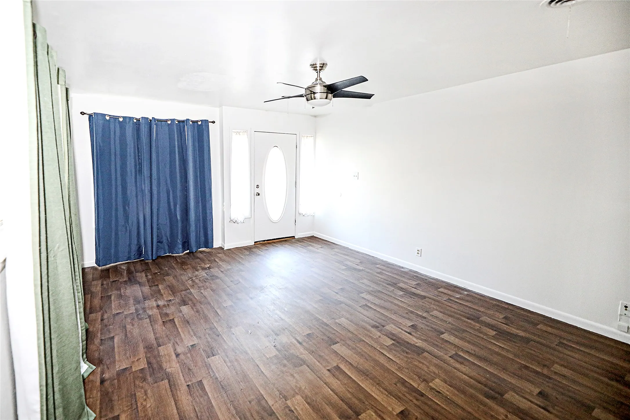 Foyer entrance with dark wood-style floors and a ceiling fan