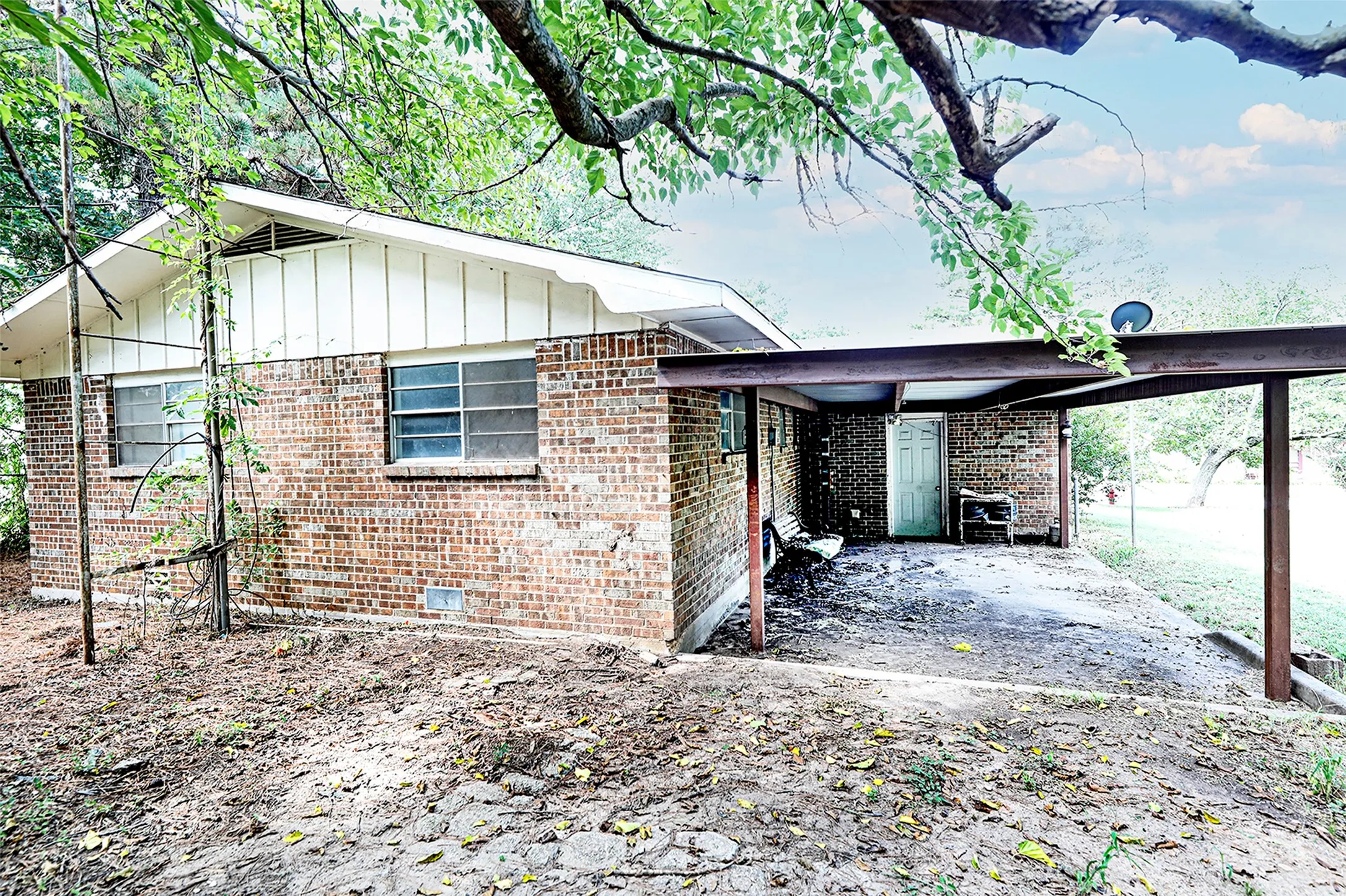View of property exterior with board and batten siding, brick siding, and a patio area