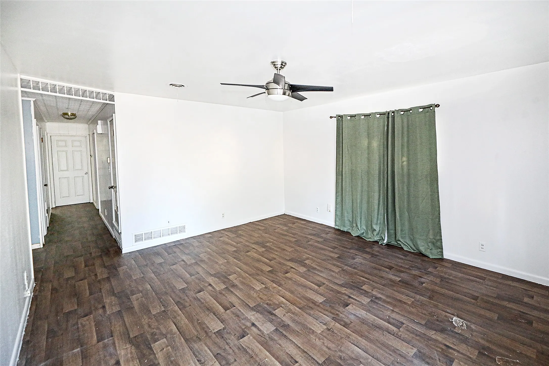 Spare room with dark wood-type flooring and ceiling fan