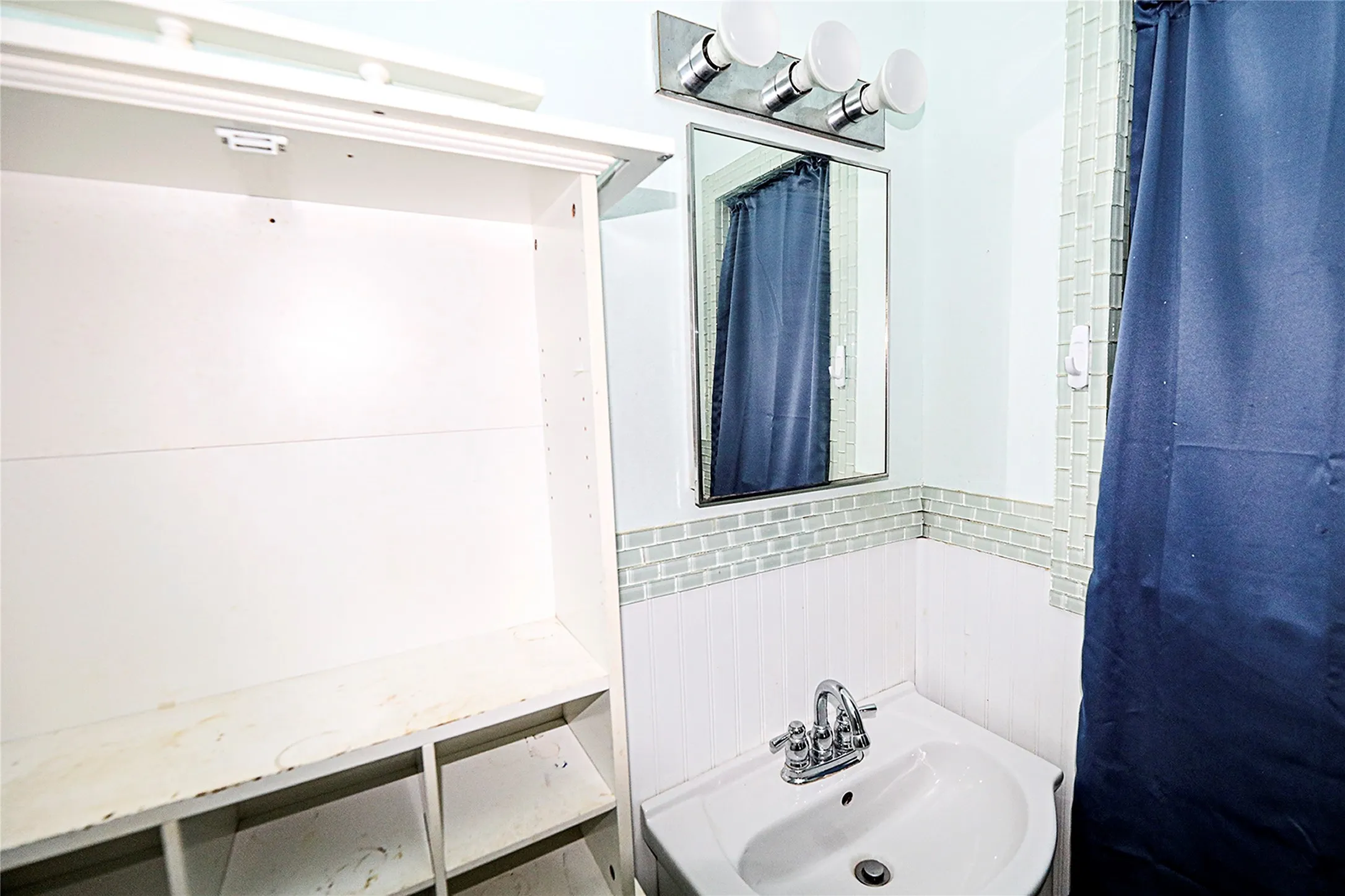 Bathroom featuring a sink and tile walls