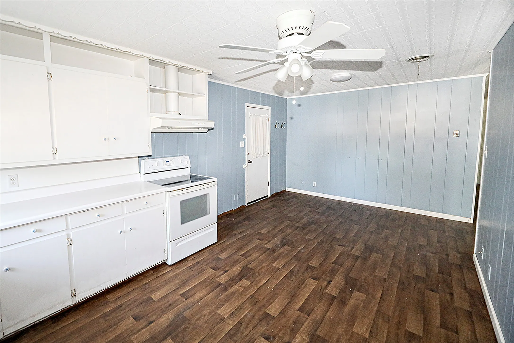 Kitchen with open shelves, white range with electric stovetop, white cabinetry, light countertops, and dark wood finished floors
