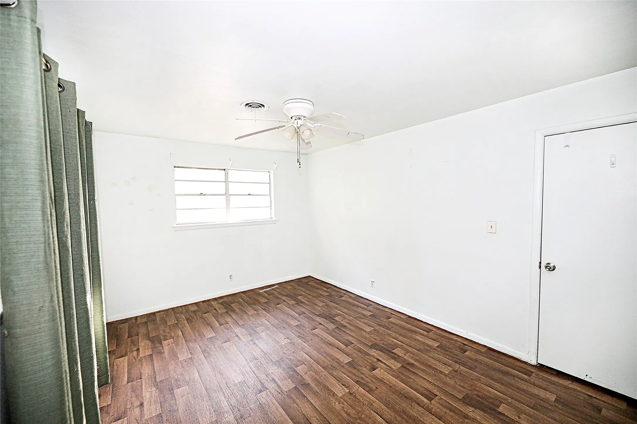 Unfurnished bedroom with dark wood-style floors and ceiling fan