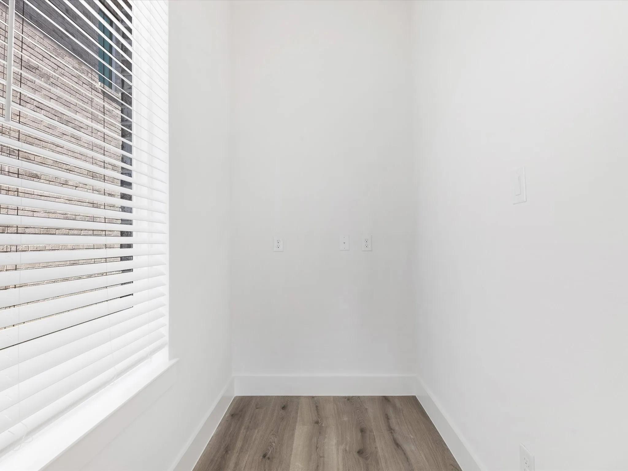 Spare room featuring light wood-style flooring and baseboards