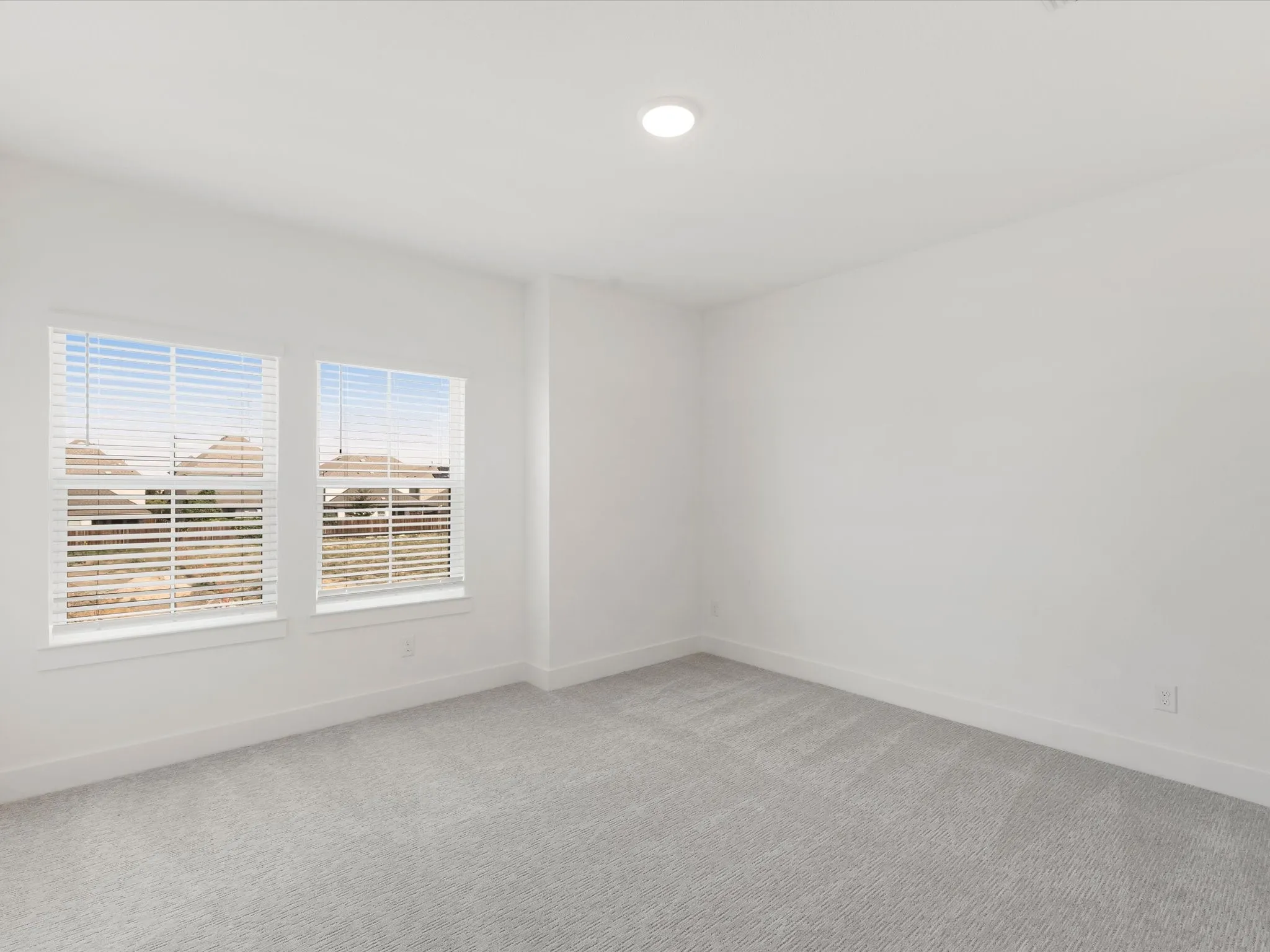Bedroom 4 featuring light colored carpet and baseboards