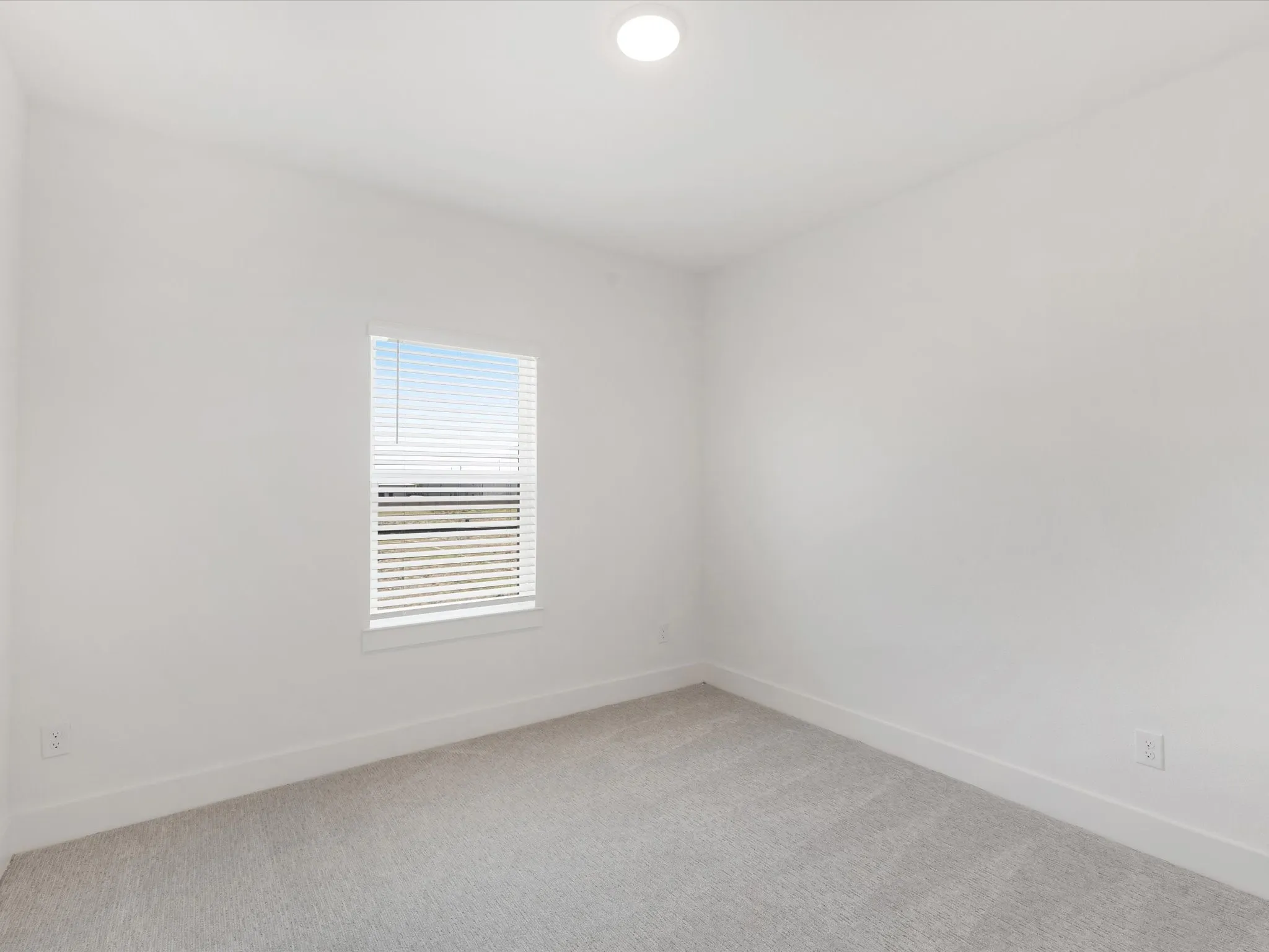 Bedroom 2 with baseboards and light colored carpet