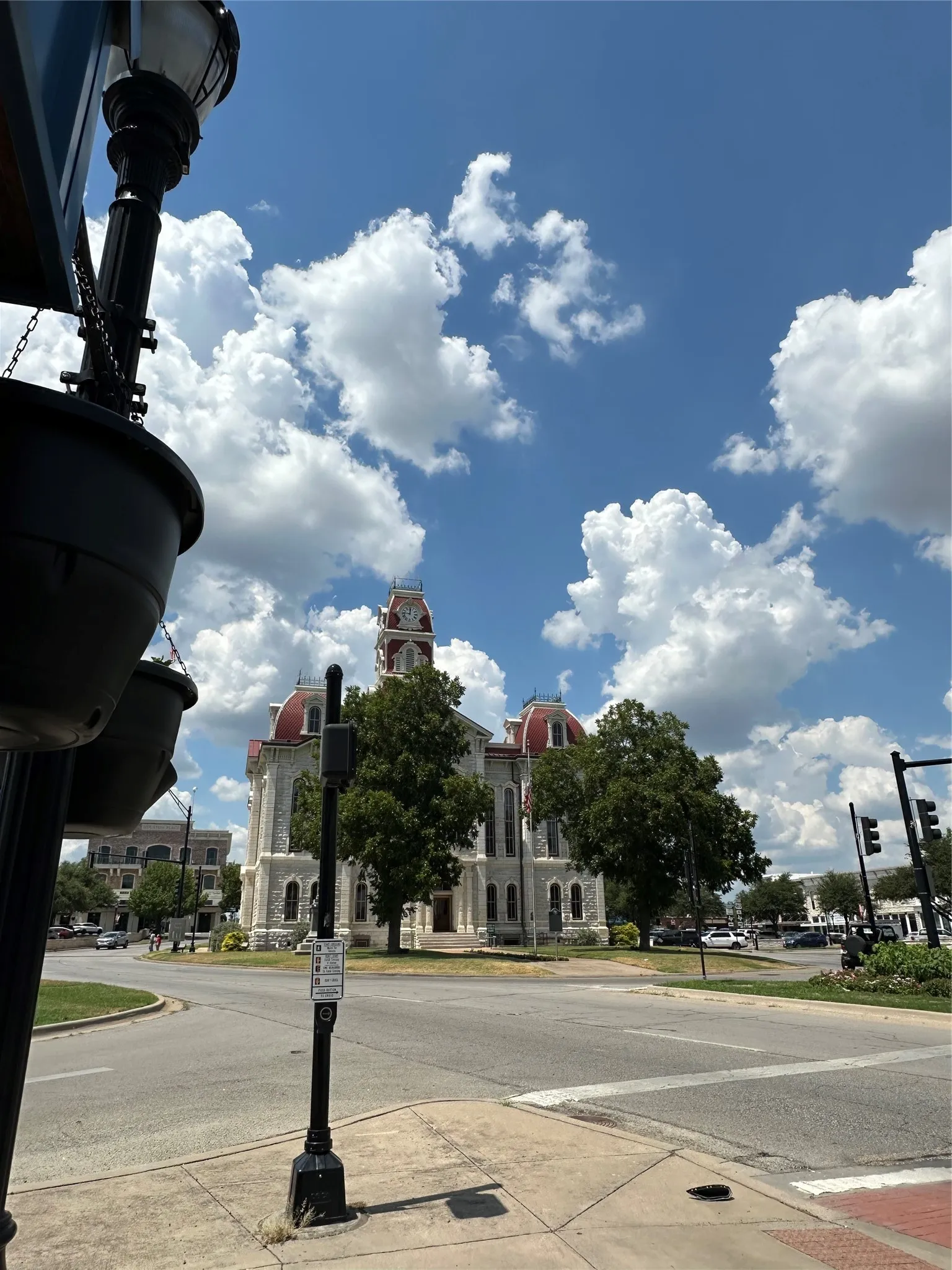 View of asphalt street with curbs, sidewalks, and street lights
