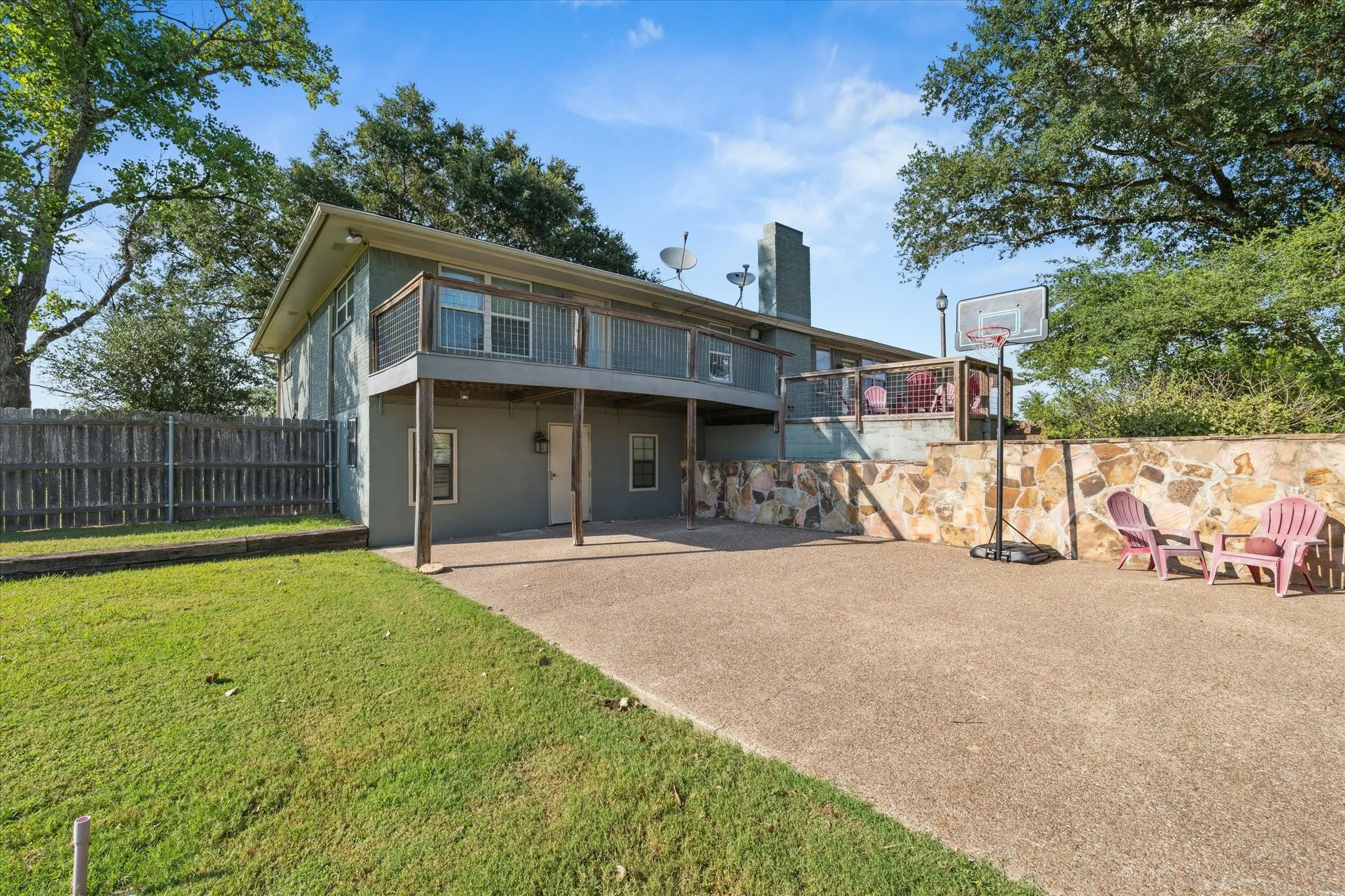 Rear view of house with a patio area, a chimney, stucco siding, and a wooden deck