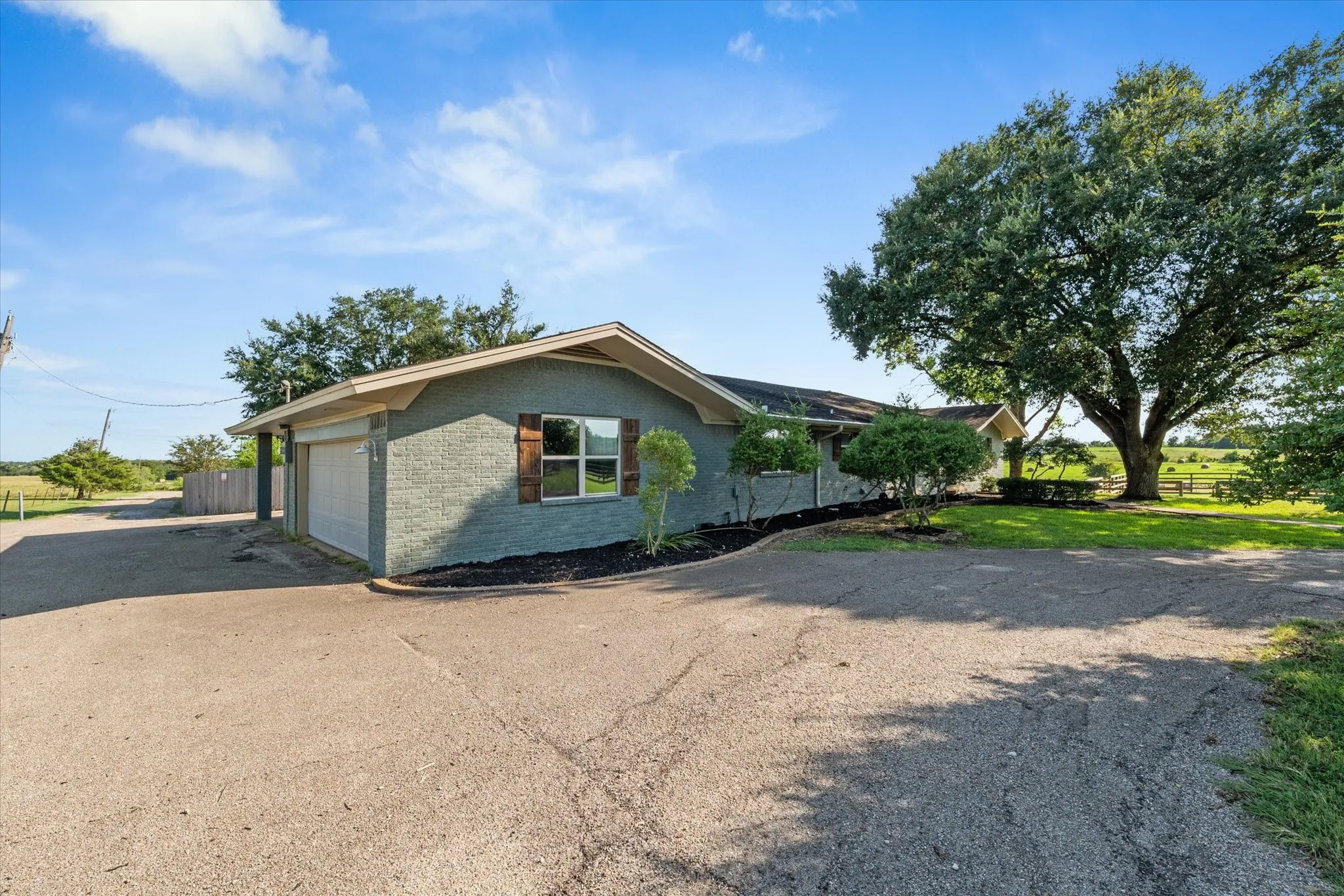 View of side of home with brick siding, driveway, and a garage