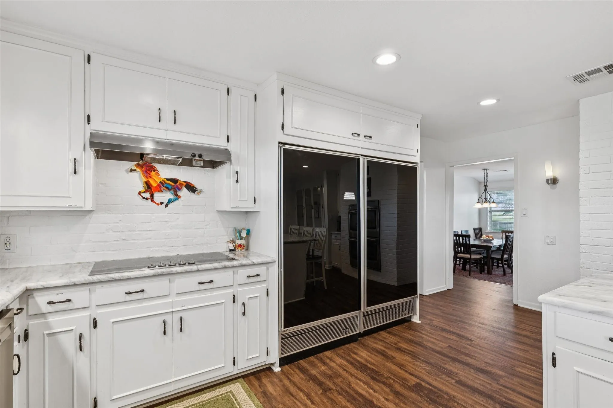 Kitchen featuring white cabinetry, tasteful backsplash, recessed lighting, dark wood-style floors, and under cabinet range hood