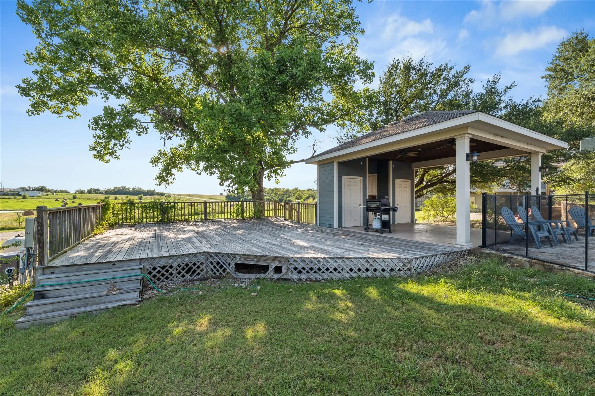 Wooden deck with a lawn and area for grilling
