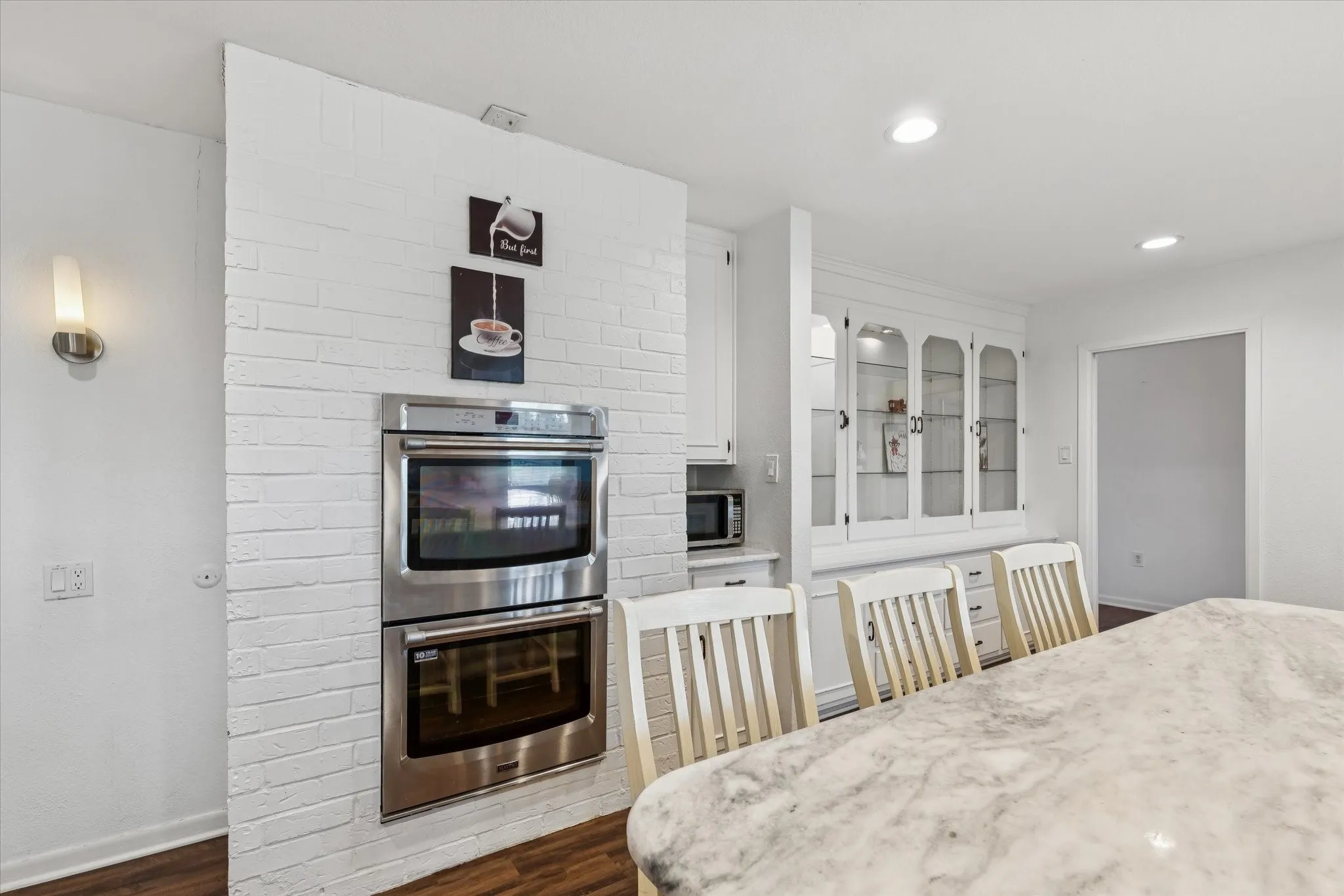 Kitchen featuring white cabinets, appliances with stainless steel finishes, dark wood-style flooring, recessed lighting, and glass insert cabinets